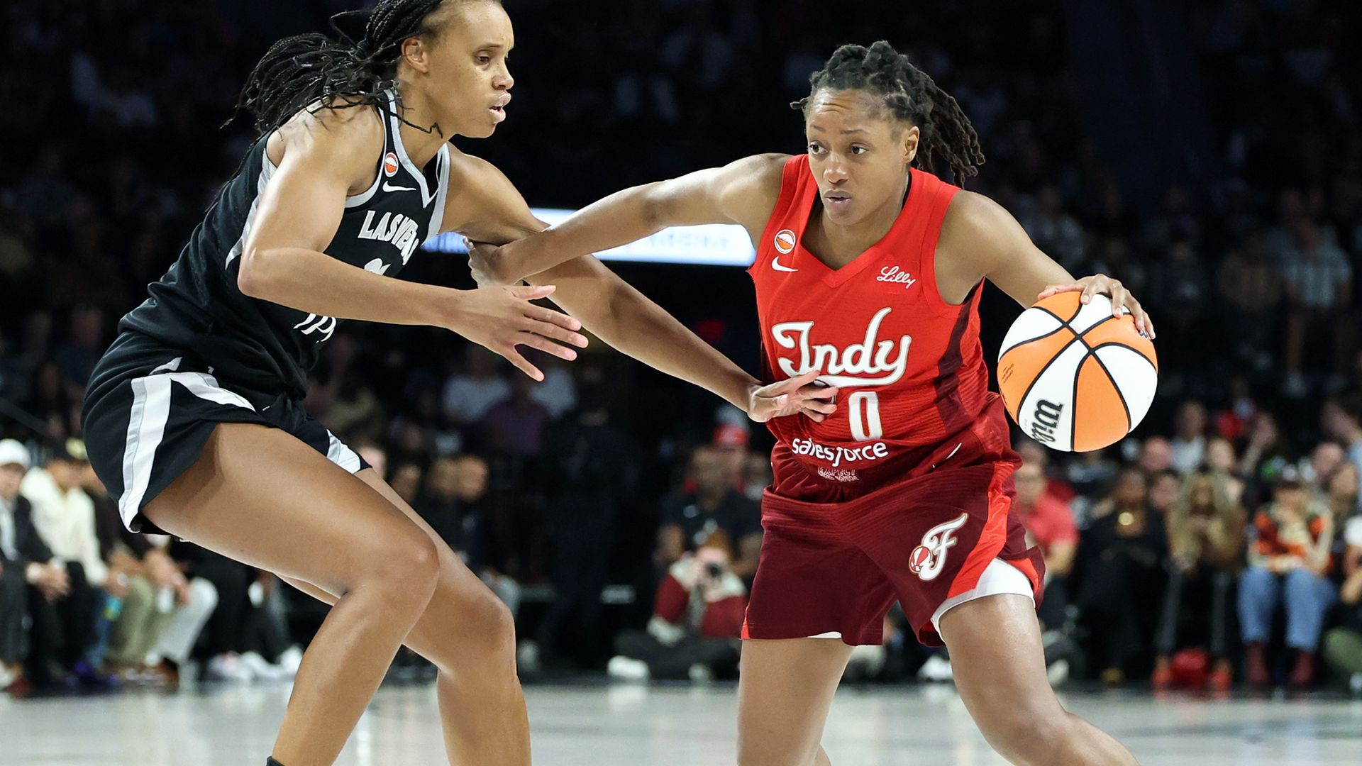 Kelsey Mitchell #0 of the Indiana Fever drives against Brianna Turner #21 of the Las Vegas Aces in the third quarter of Game Three of the 2026 WNBA Playoffs first round at Michelob ULTRA Arena on October 01, 2026 in Las Vegas, Nevada. The Aces defeated the Fever 94-83 to win the series two games to 