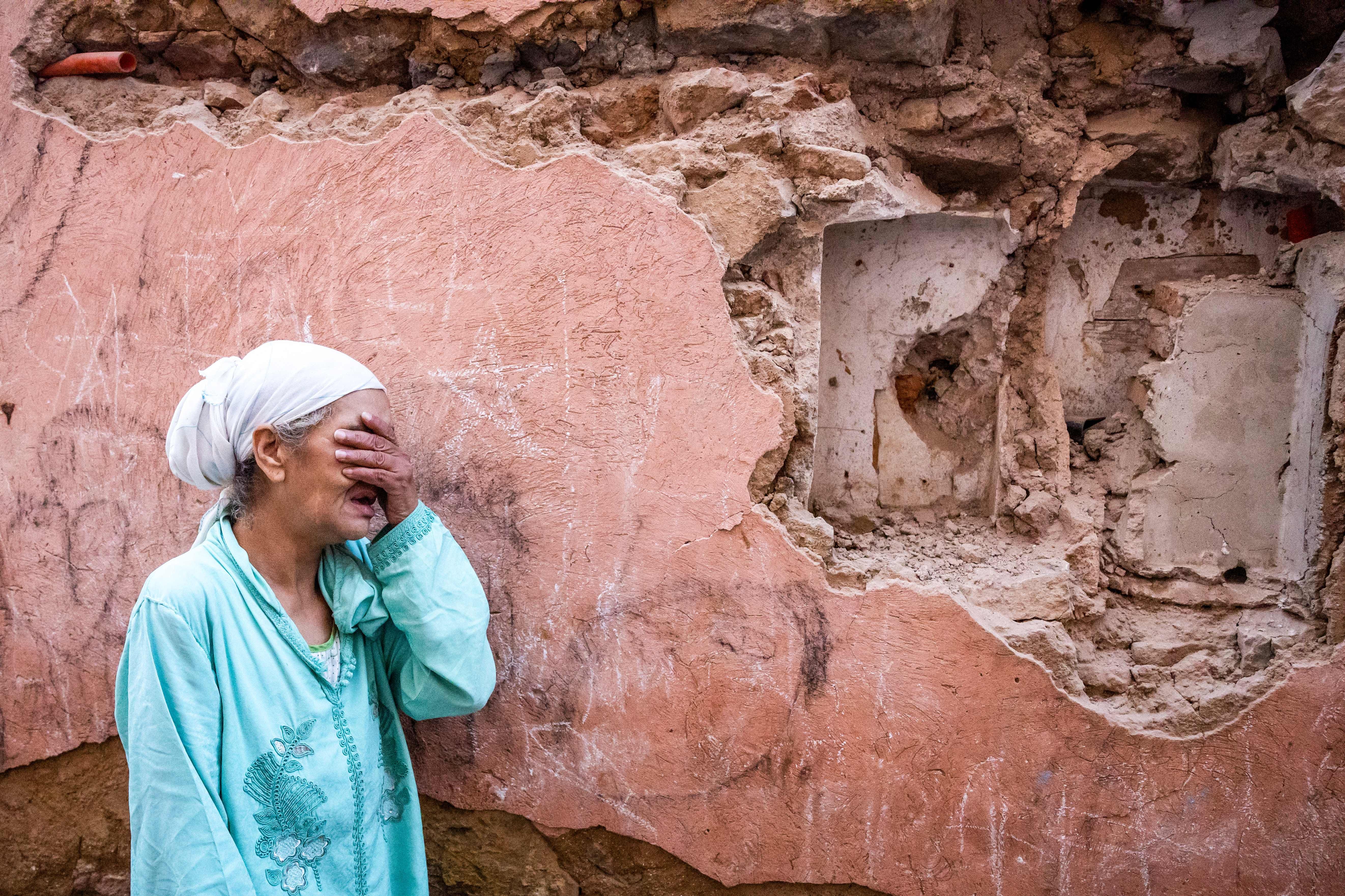 A woman reacts standing infront of her earthquake-damaged house in the old city in Marrakesh