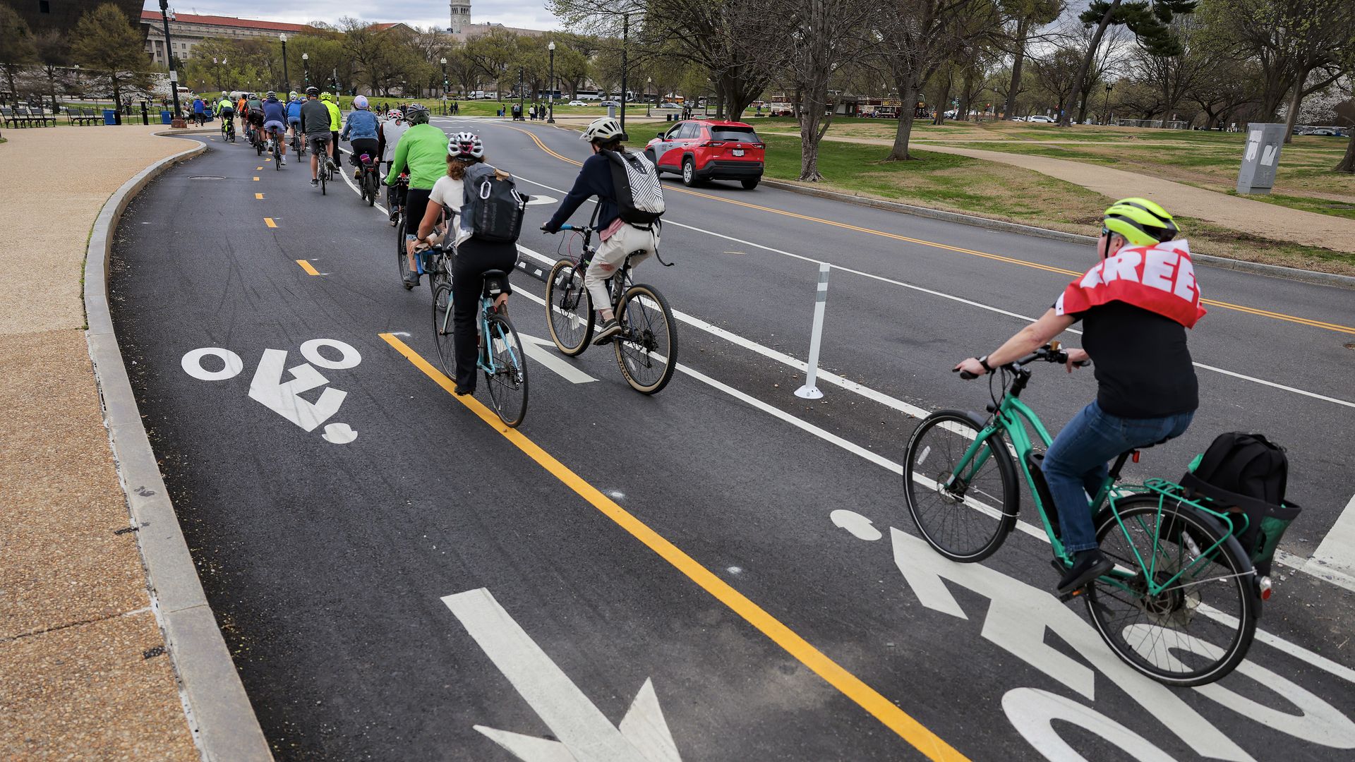 Cyclists ride up and down the 15th Street bike lane by the National Mall