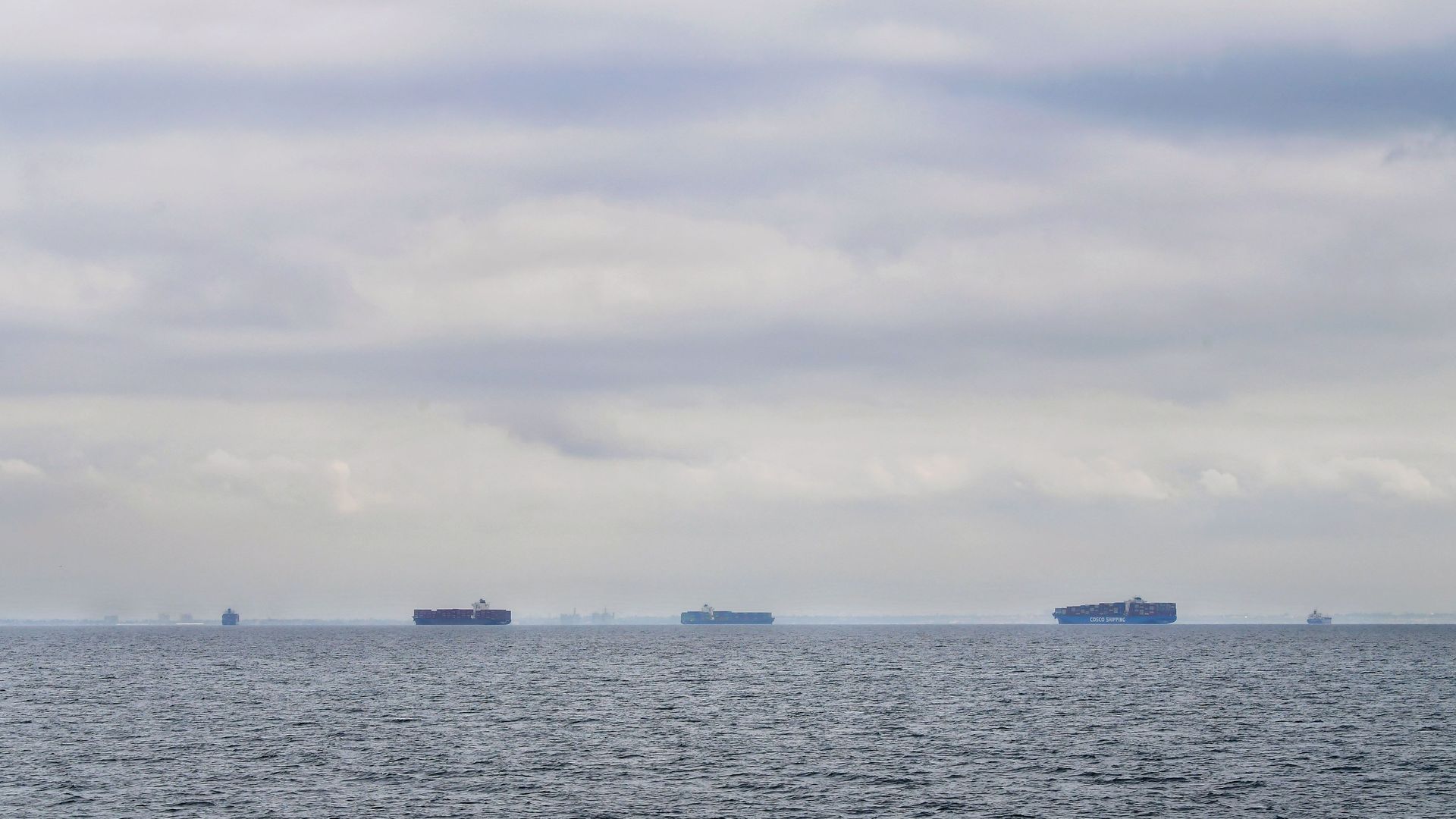 Cargo ships filled with containers wait offshore for entry to the Port of Los Angeles or Port of Long Beach on October 6, 2021 off the coast of San Pedro, California