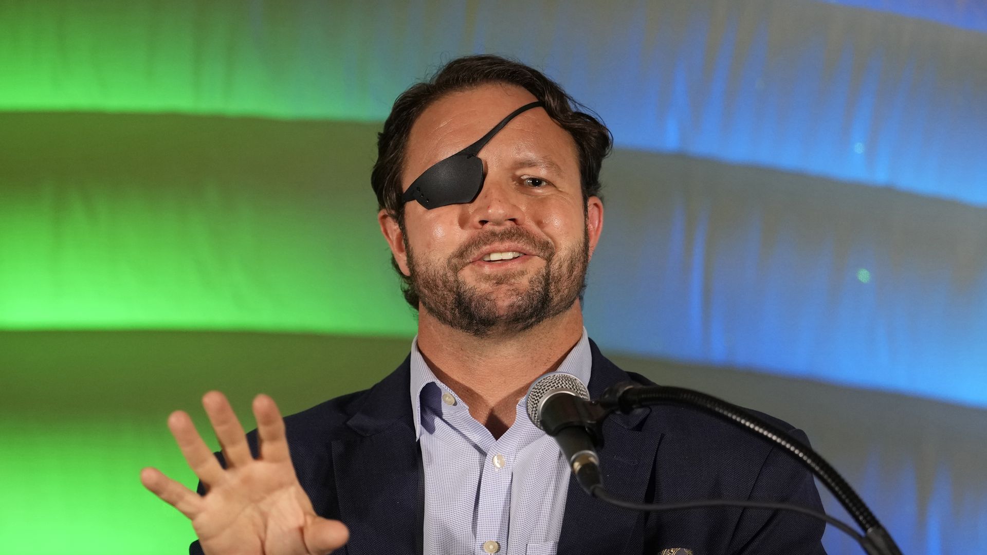Rep. Dan Crenshaw in front of a blue and green background