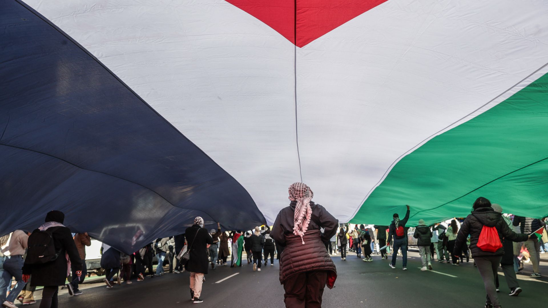 Thousands of Pro-Palestinian demonstrators hold a huge Palestinian flag as they take over New York City Streets after gathering at Washington Square Park on Black Friday in New York, United States on November 24, 2023.