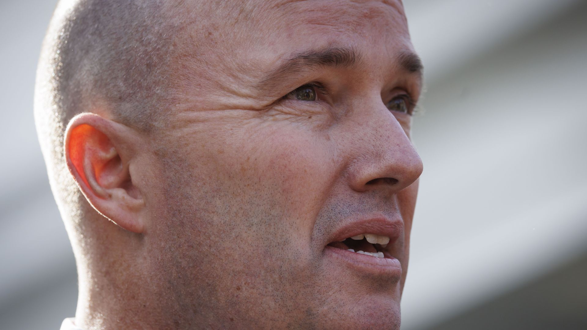 A white man's face as he squints forward