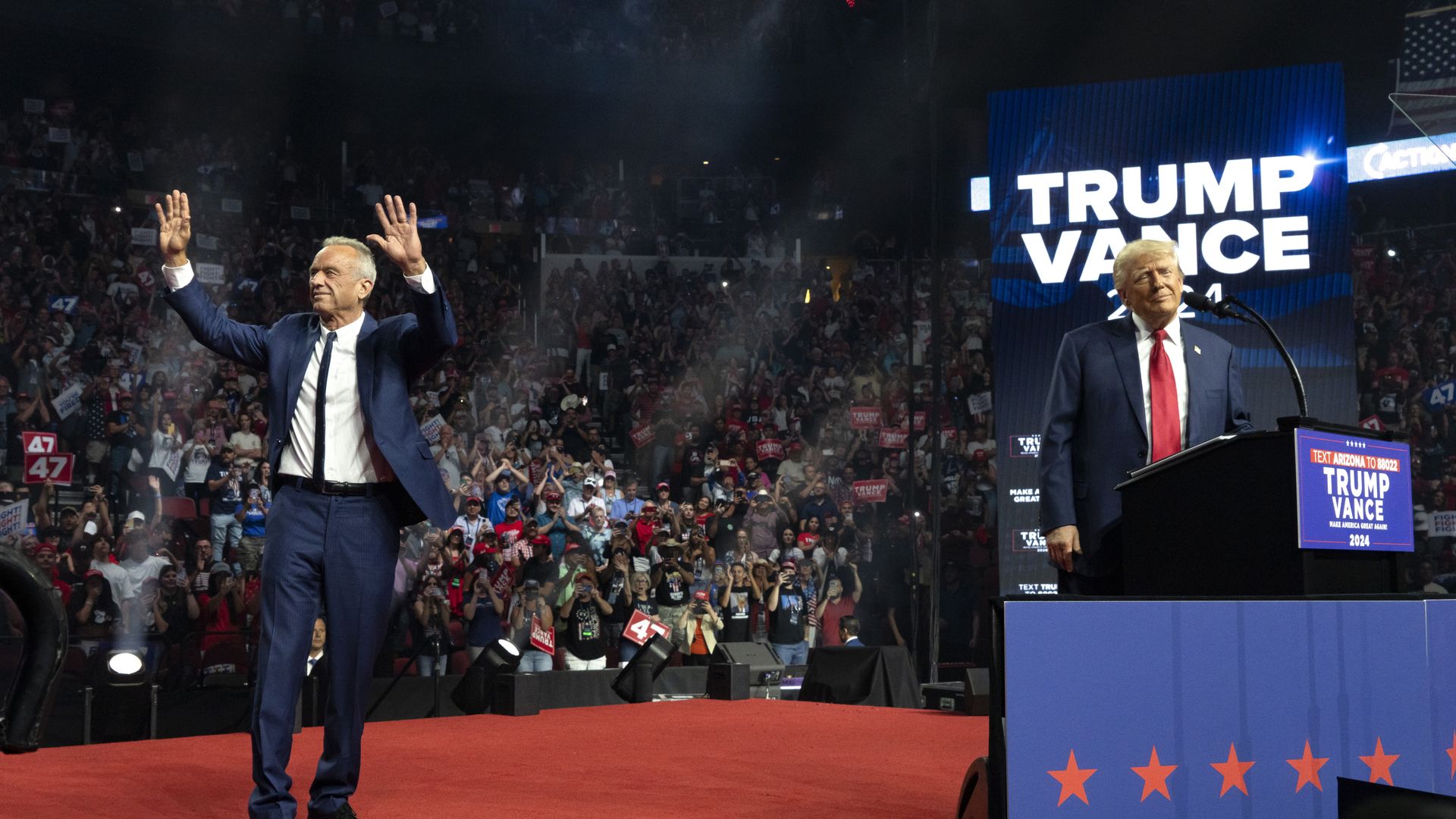 Former presidential candidate Robert F. Kennedy Jr. (L) waves as Republican presidential nominee, former U.S. President Donald Trump reacts during a campaign rally at Desert Diamond Arena on August 23, 2024 in Glendale, Arizona.