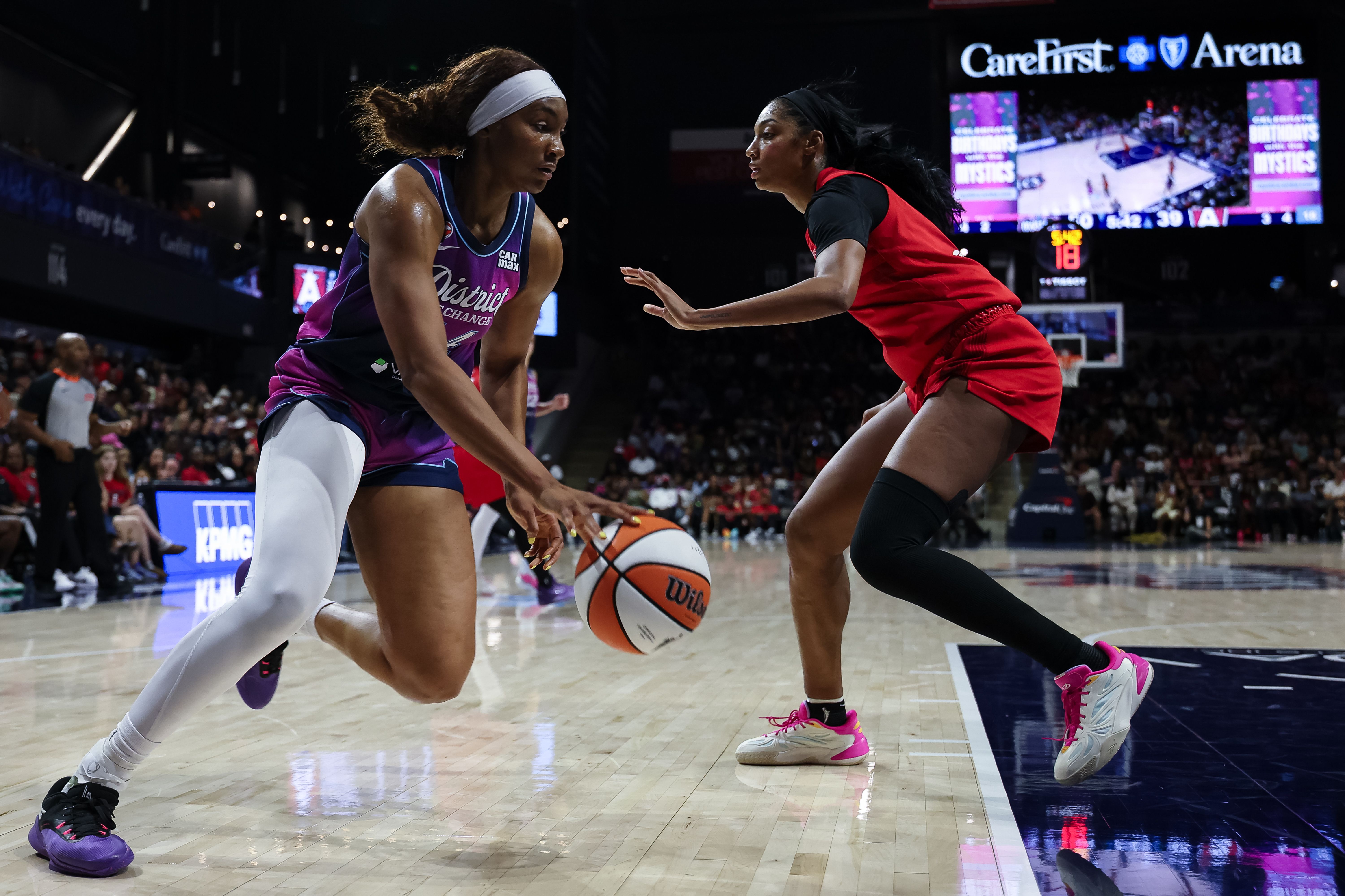 Kiki Iriafen drives to the basket against Angel Reese.
