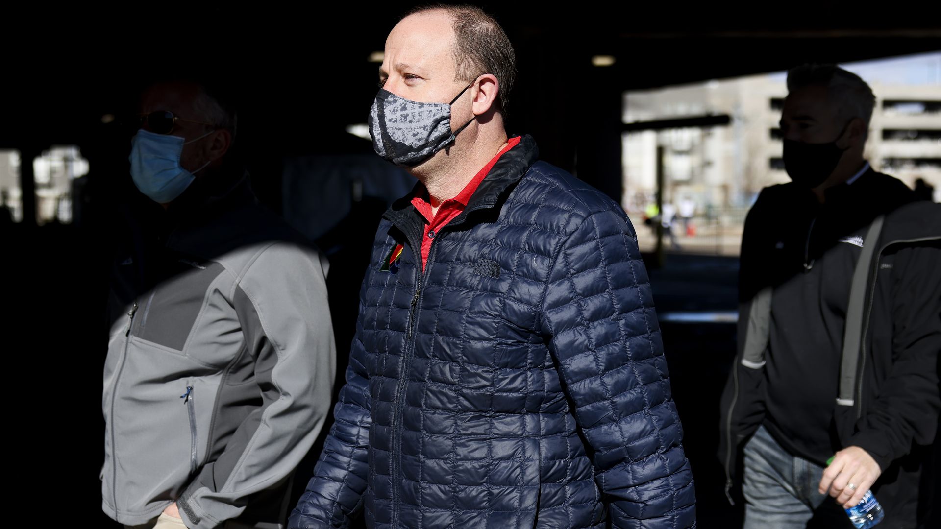 Colorado Gov. Jared Polis, center, visits a mass COVID-19 vaccination event. 