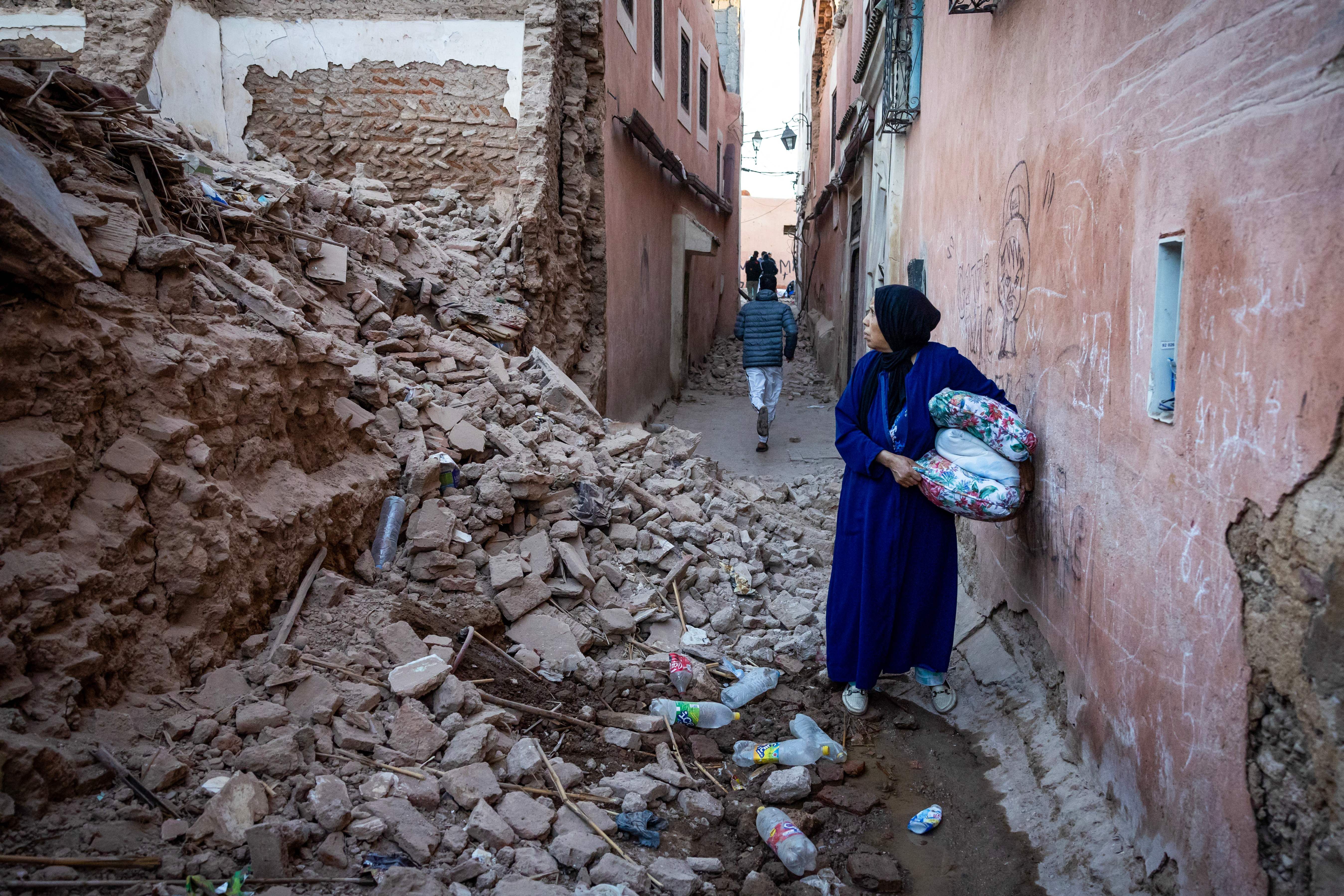  A woman looks at the rubble of a building in the earthquake-damaged old city in Marrakesh on September 9, 2023. 