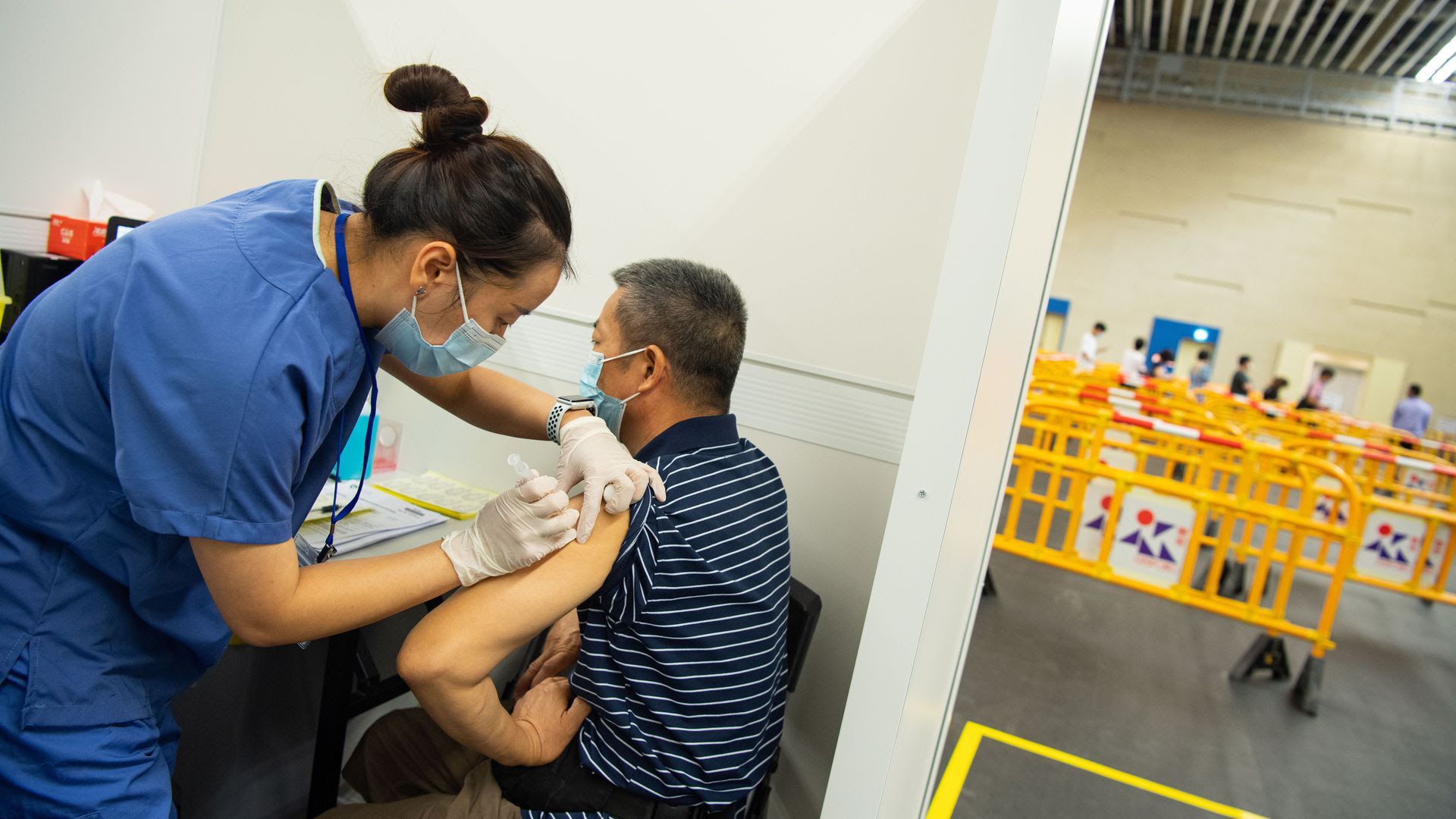 Nurse in China administers a vaccine dose to an elderly man