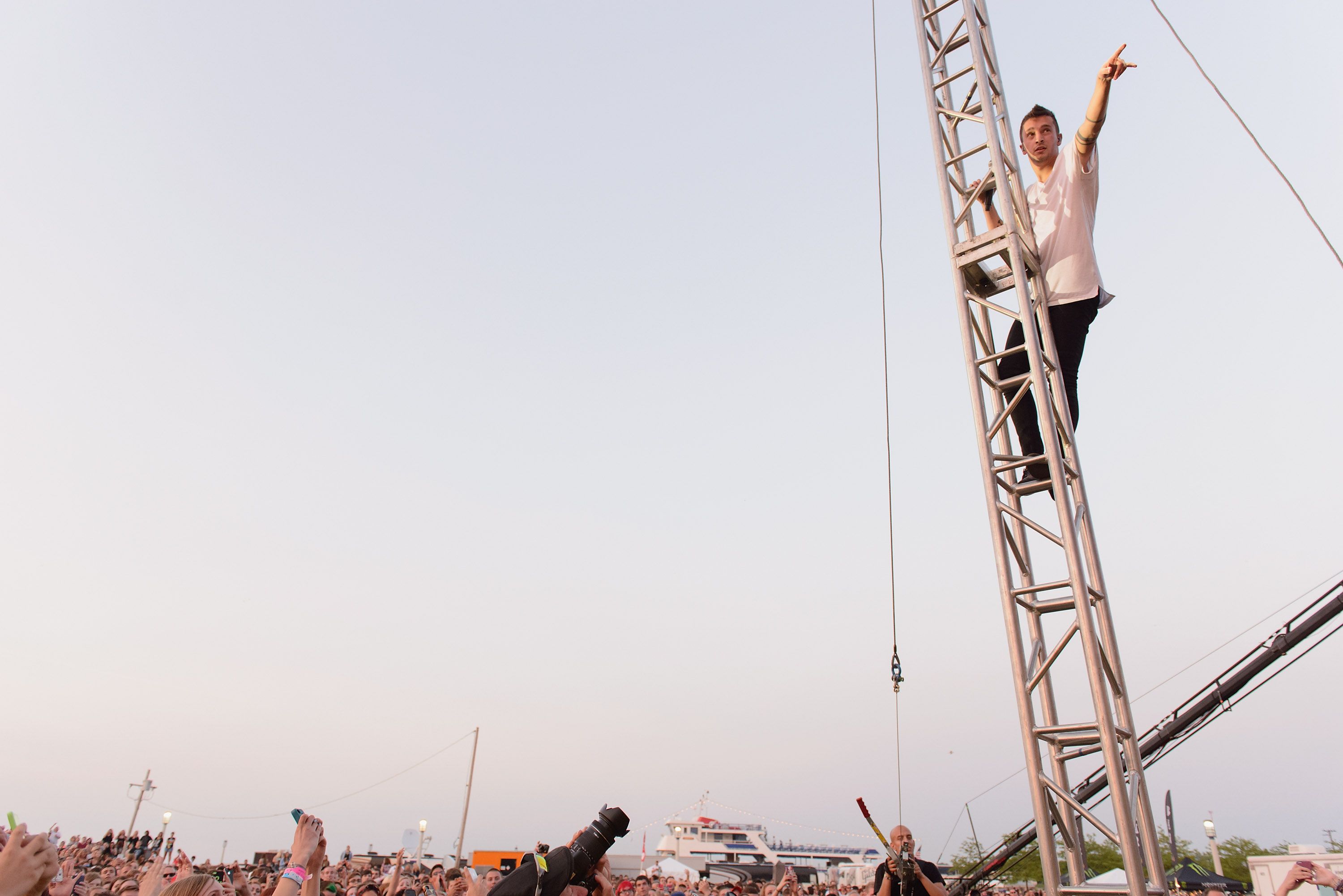 A performer scales a scaffolding above a crowd.