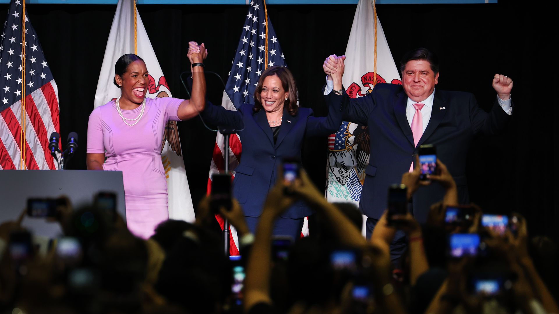 Photo of three people holding hands on stage 