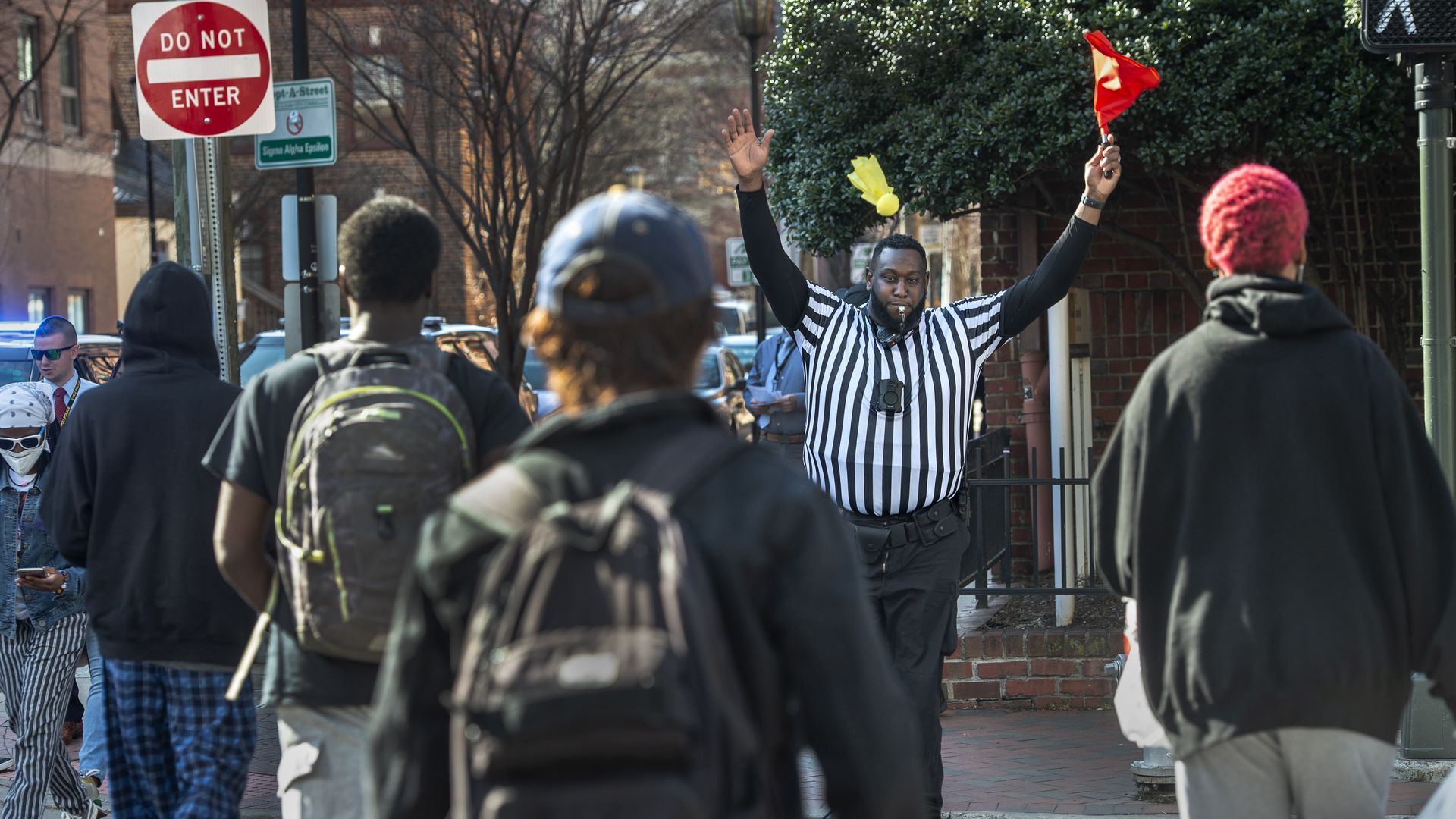 A VCU Police officer tosses a yellow flag after a pedestrian strayed outside of the crosswalk at Shafer and West Grace.