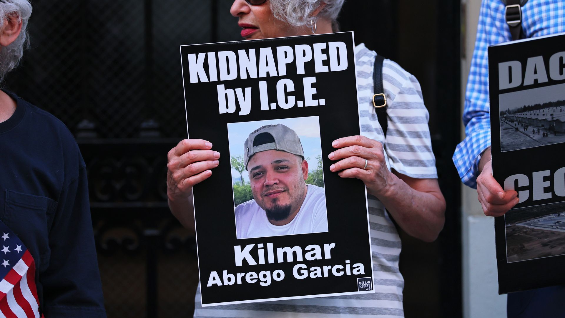Woman holds photo of Abrego Garcia in cap