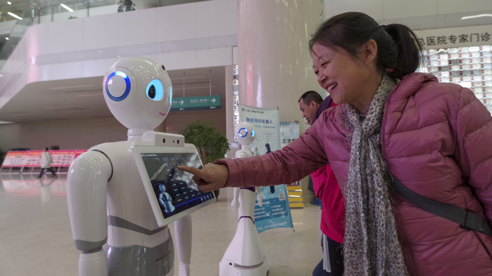 Several intelligent guide robots standing in the outpatient lobby of Beijing 301 hospital.
