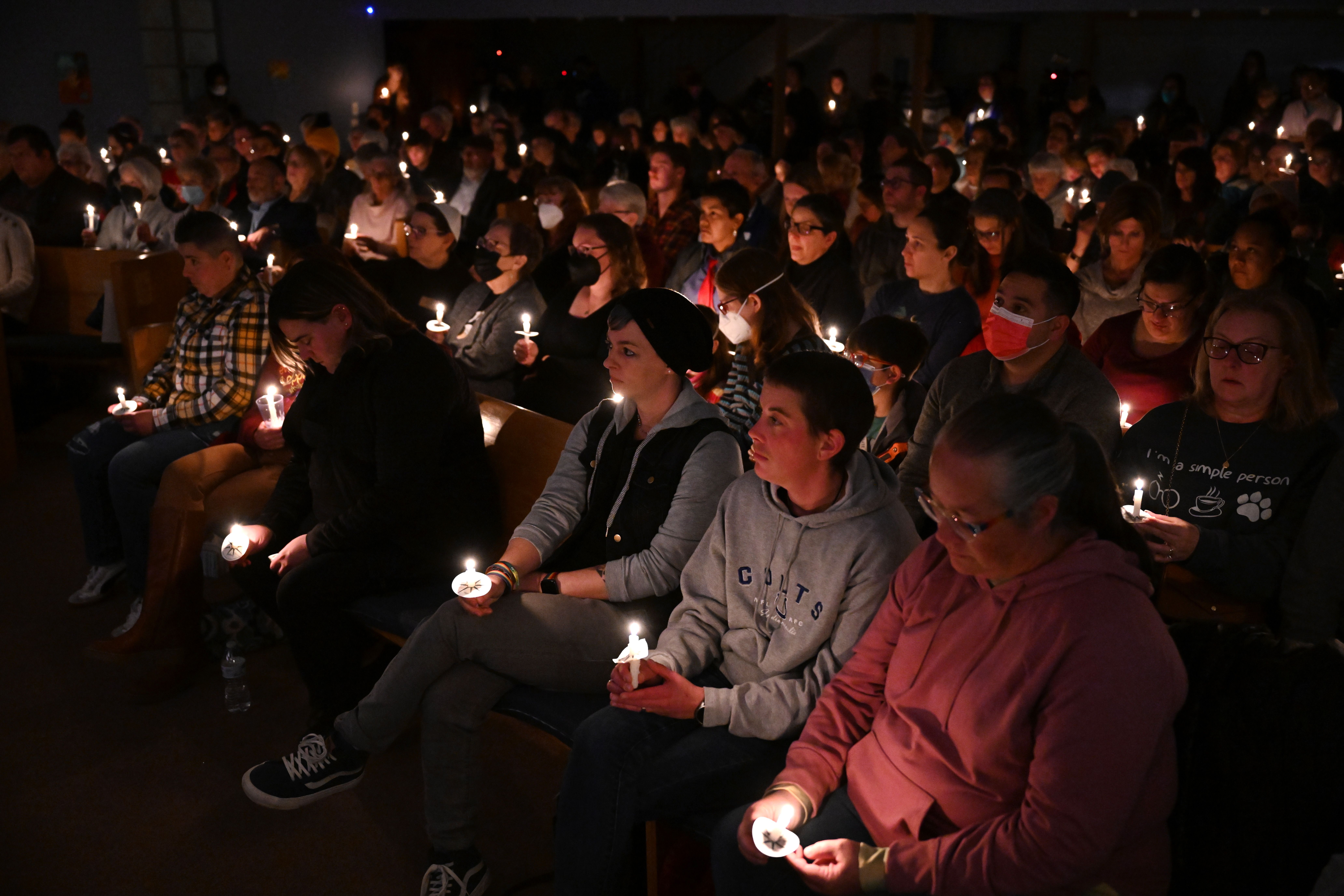 Mourners hold candles during a candlelight vigil and interfaith service for mass shooting victims in Colorado Springs, Colorado