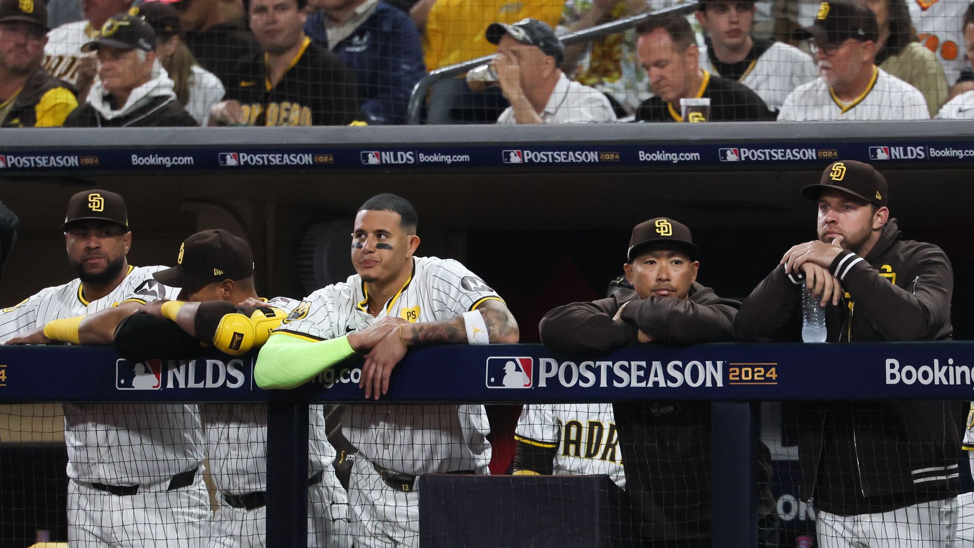 Padres players stand in the dugout. 