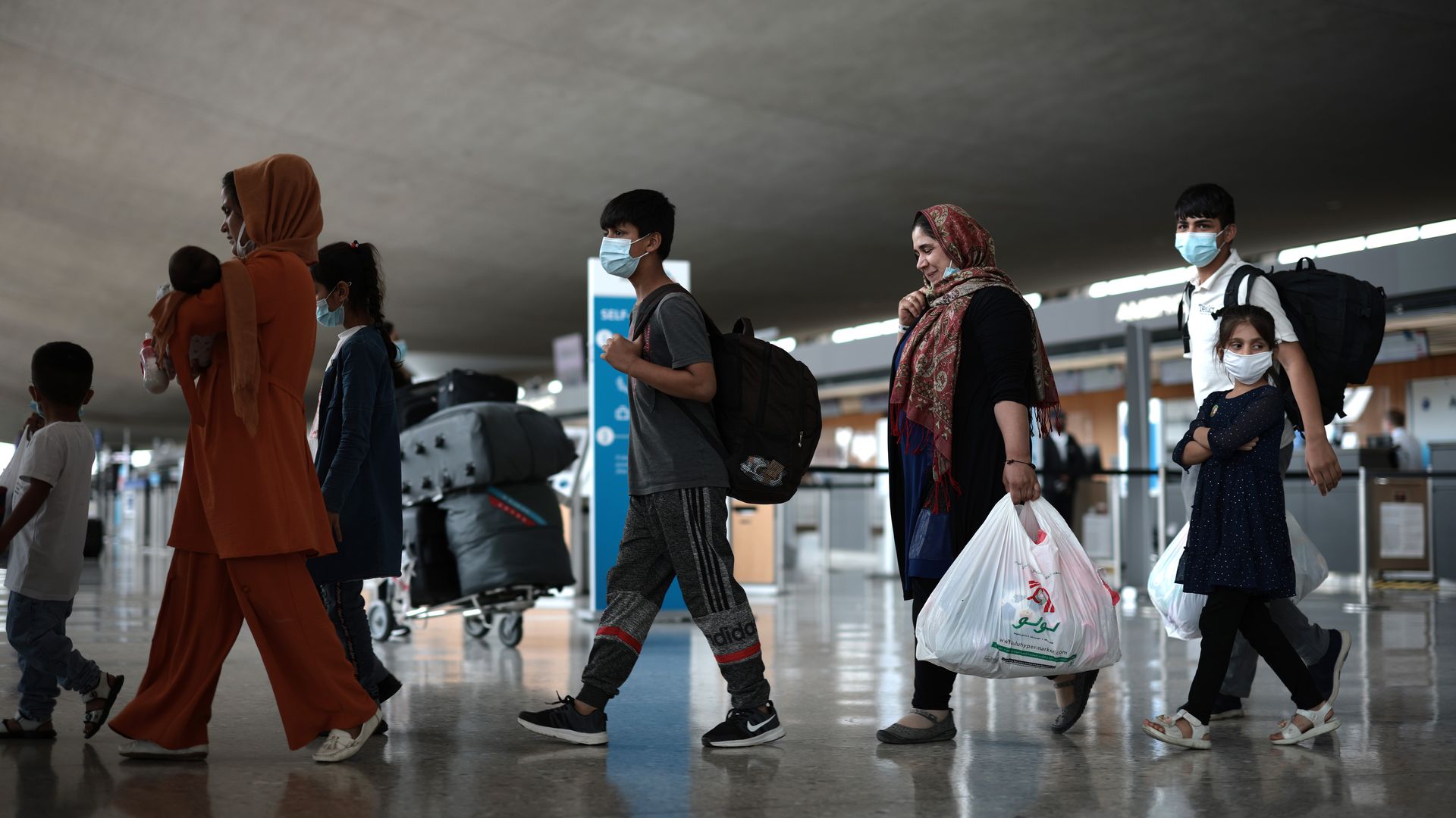 a group of people walking out of an airport