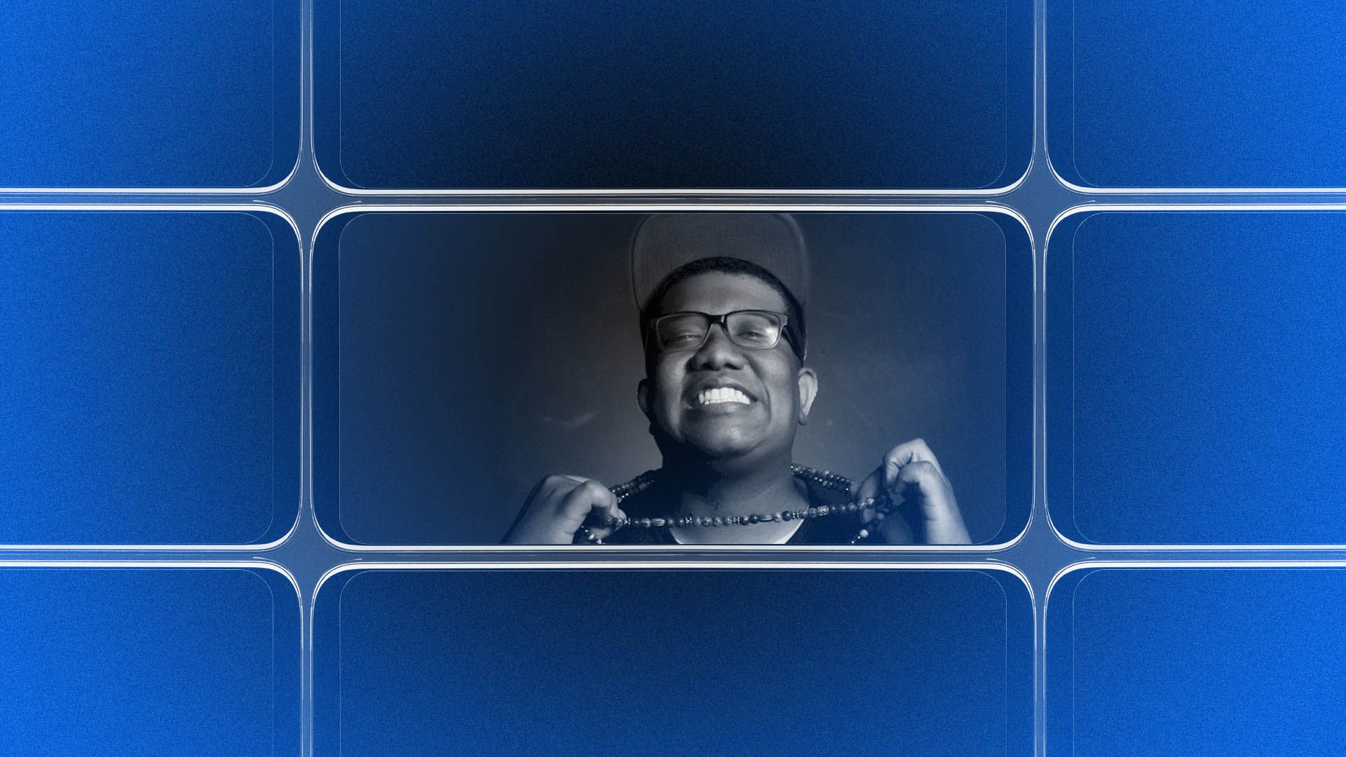 Comedian David Perdue holds a necklace and smiles at the camera