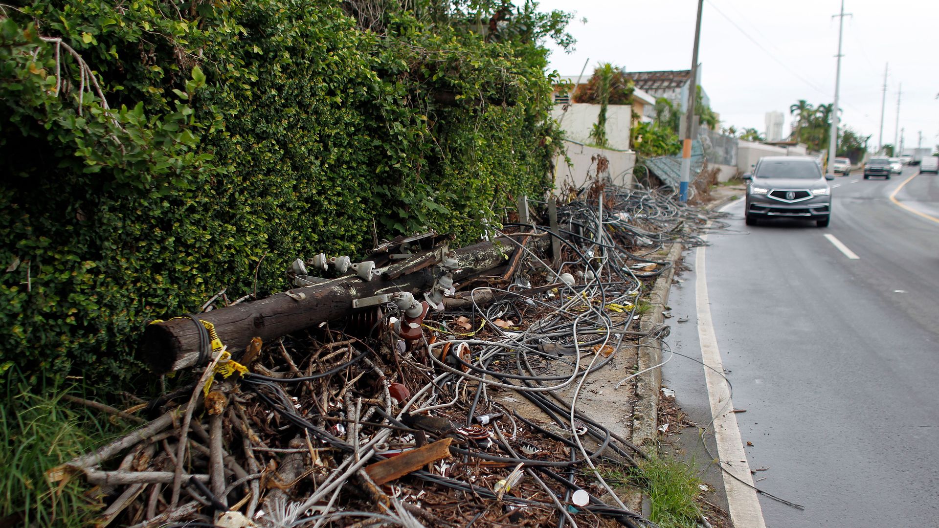 Power line poles and lines downed by the passing of Hurricane Maria lie on a sidewalk in San Juan, Puerto Rico on November 7, 2017.