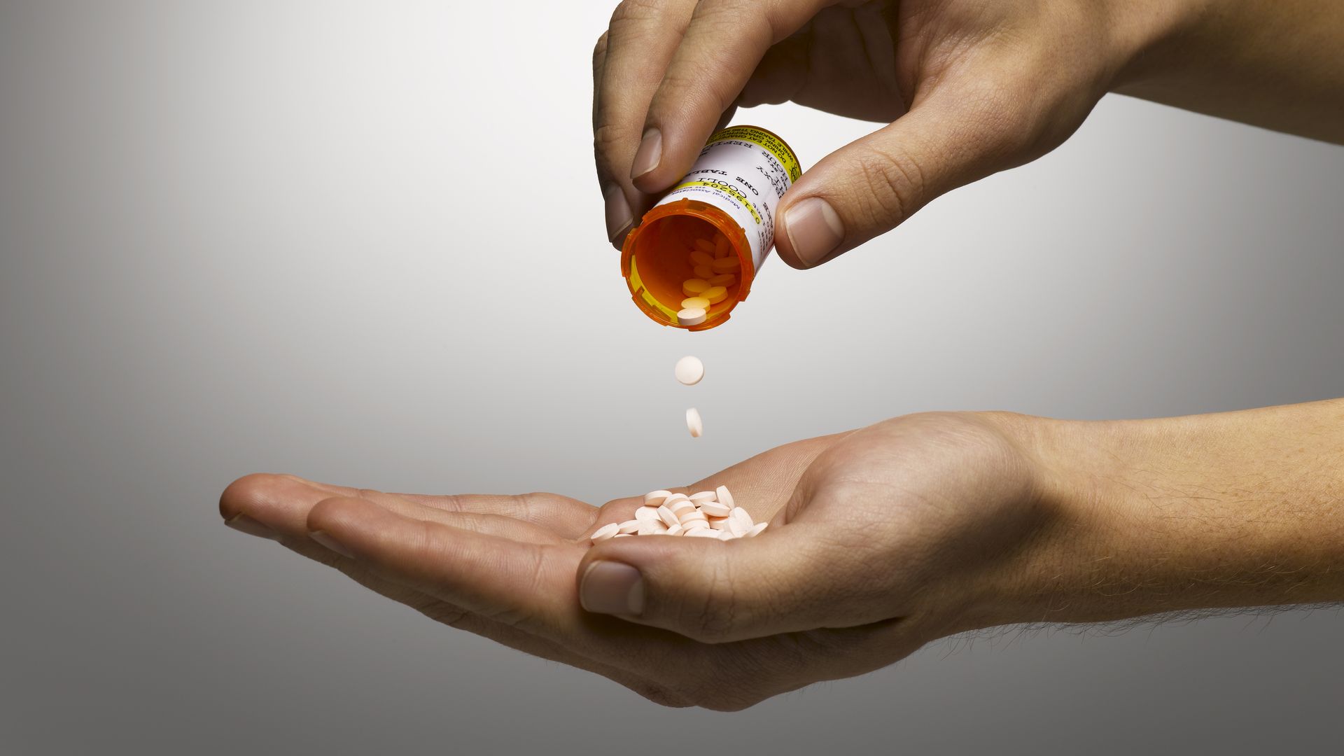 Someone pouring prescription pills into their hands