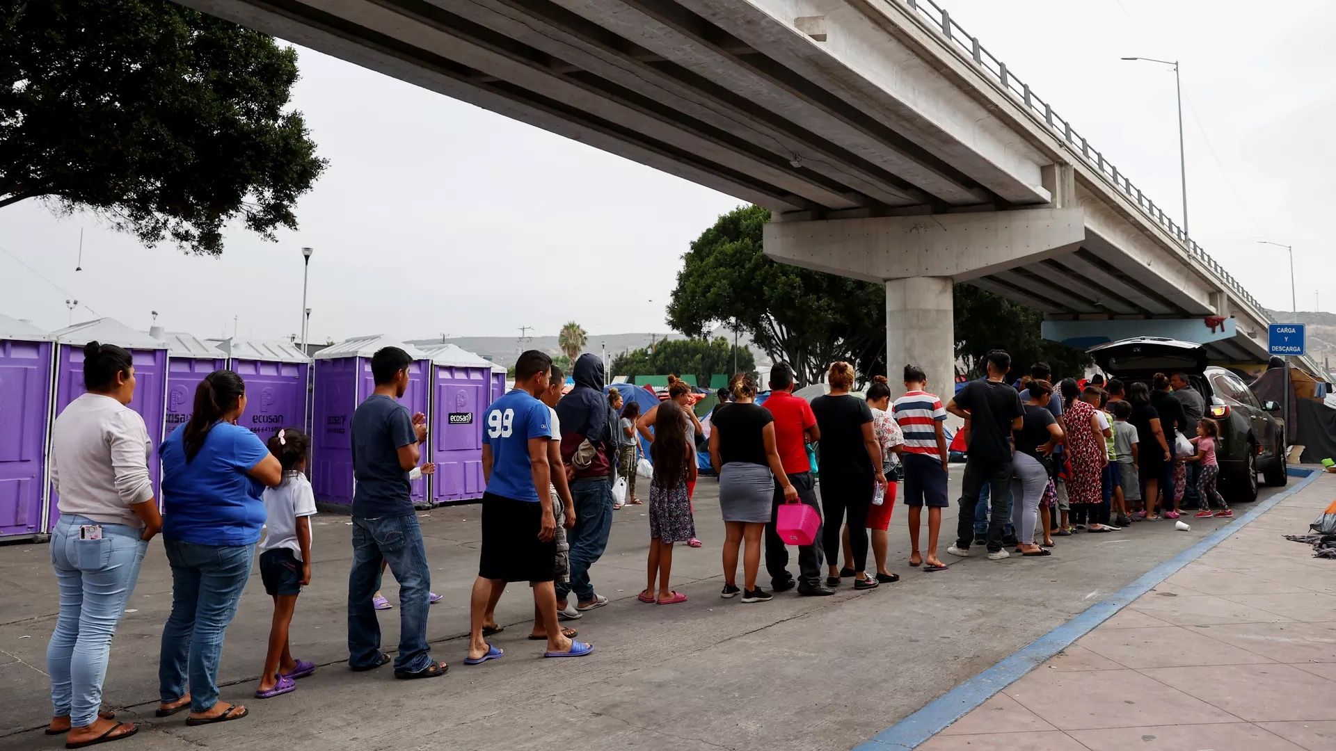 Migrants are seen lining up in Mexico for food.