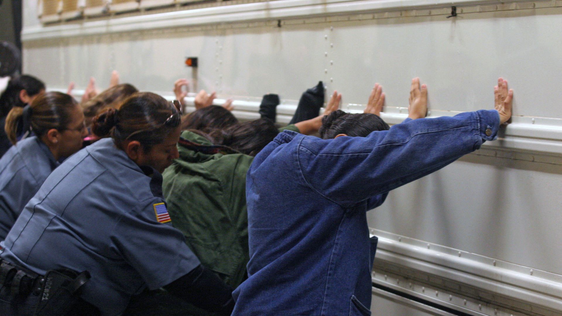 Salvadorean immigrants are told to put their hands on a bus while they are searched by the guards before being taken to the airport to be deported, at Willacy Detention facility in Raymondville, Texas on December 18, 2008.