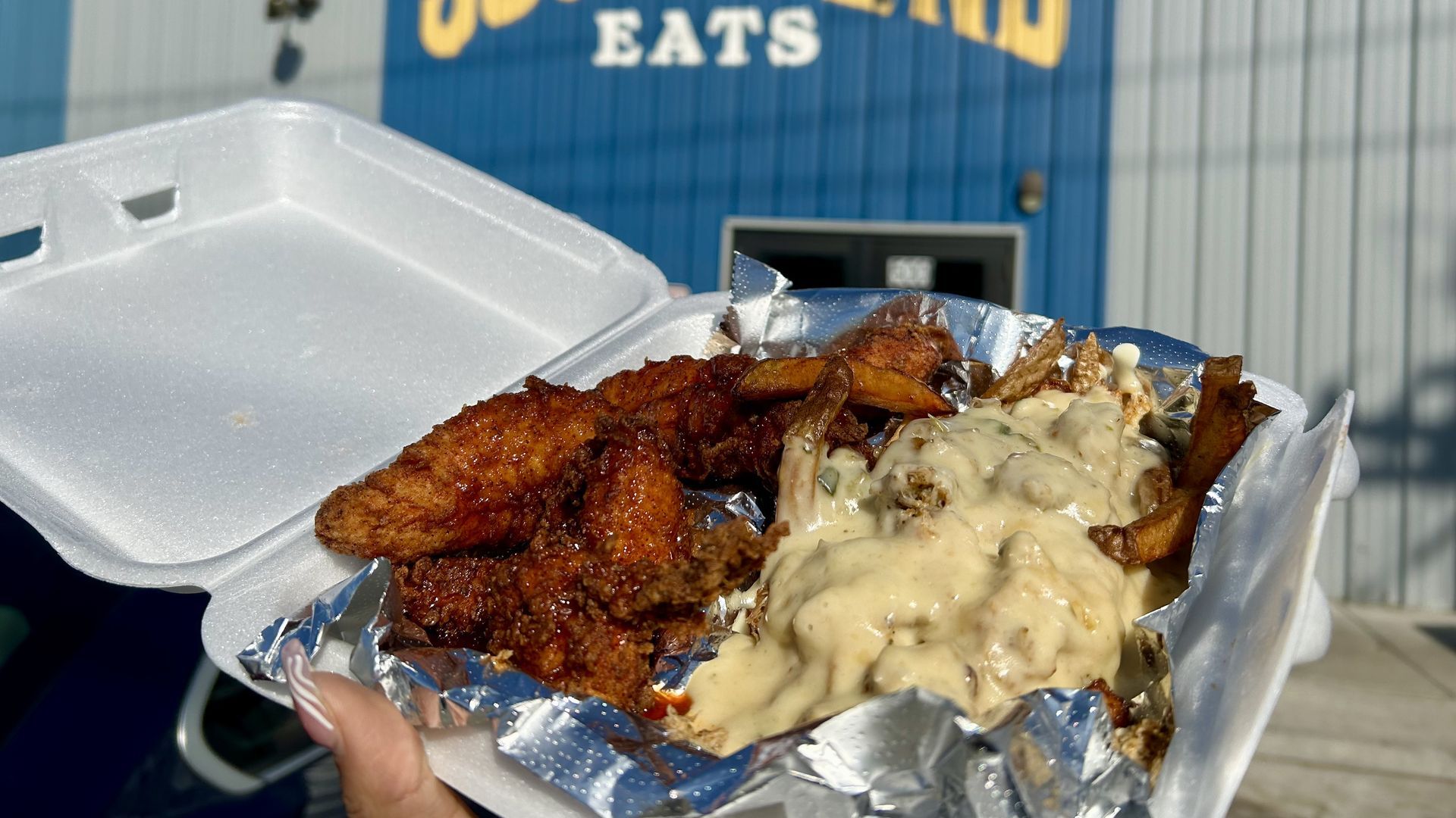 Thai chili chicken tenders with loaded queso crab fries. Photo: Alexis Clinton/Axios