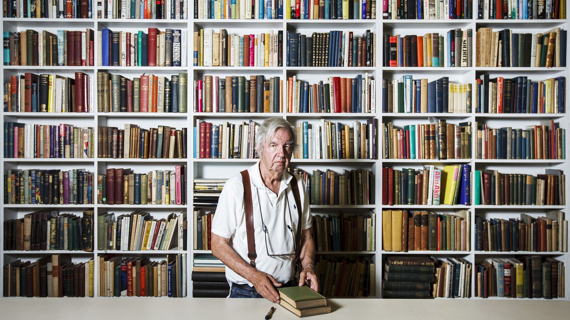 The late Larry McMurtry stands in his Archer City book store with a wall of books behind him