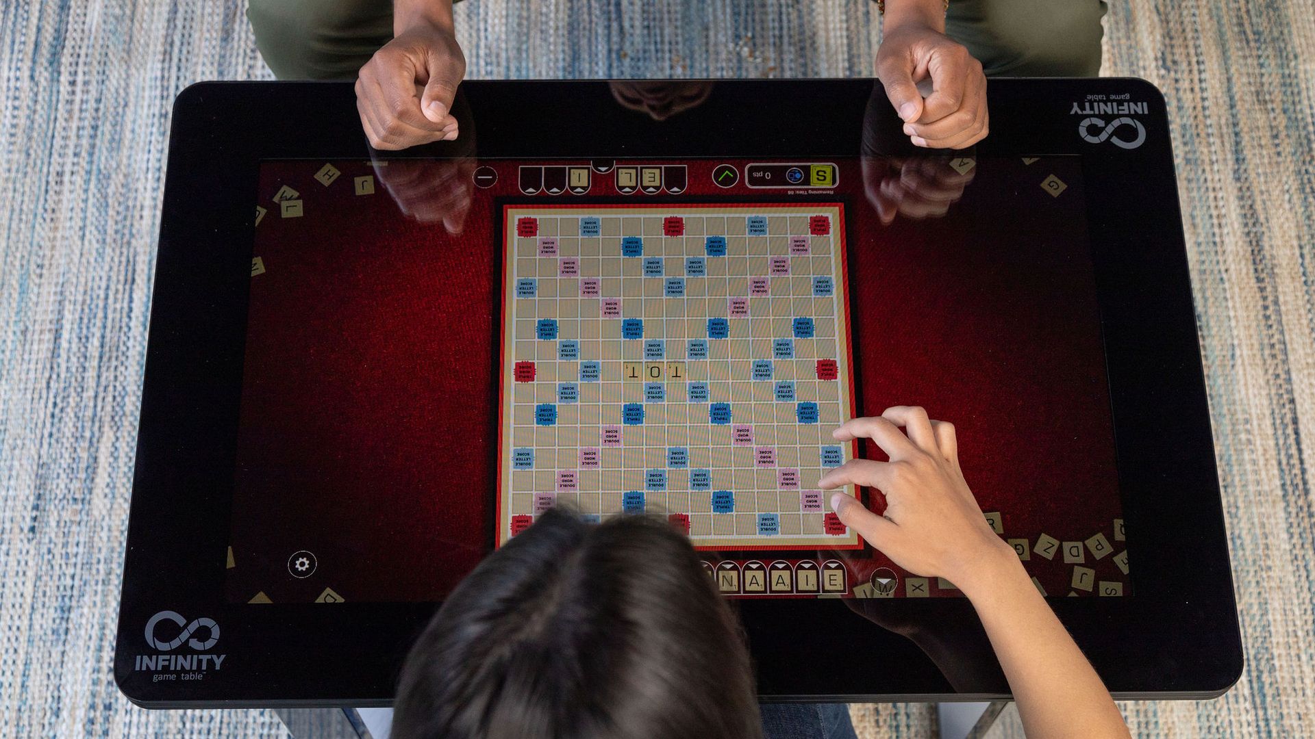 A couple plays Scrabble on the Infinity Game Table. 