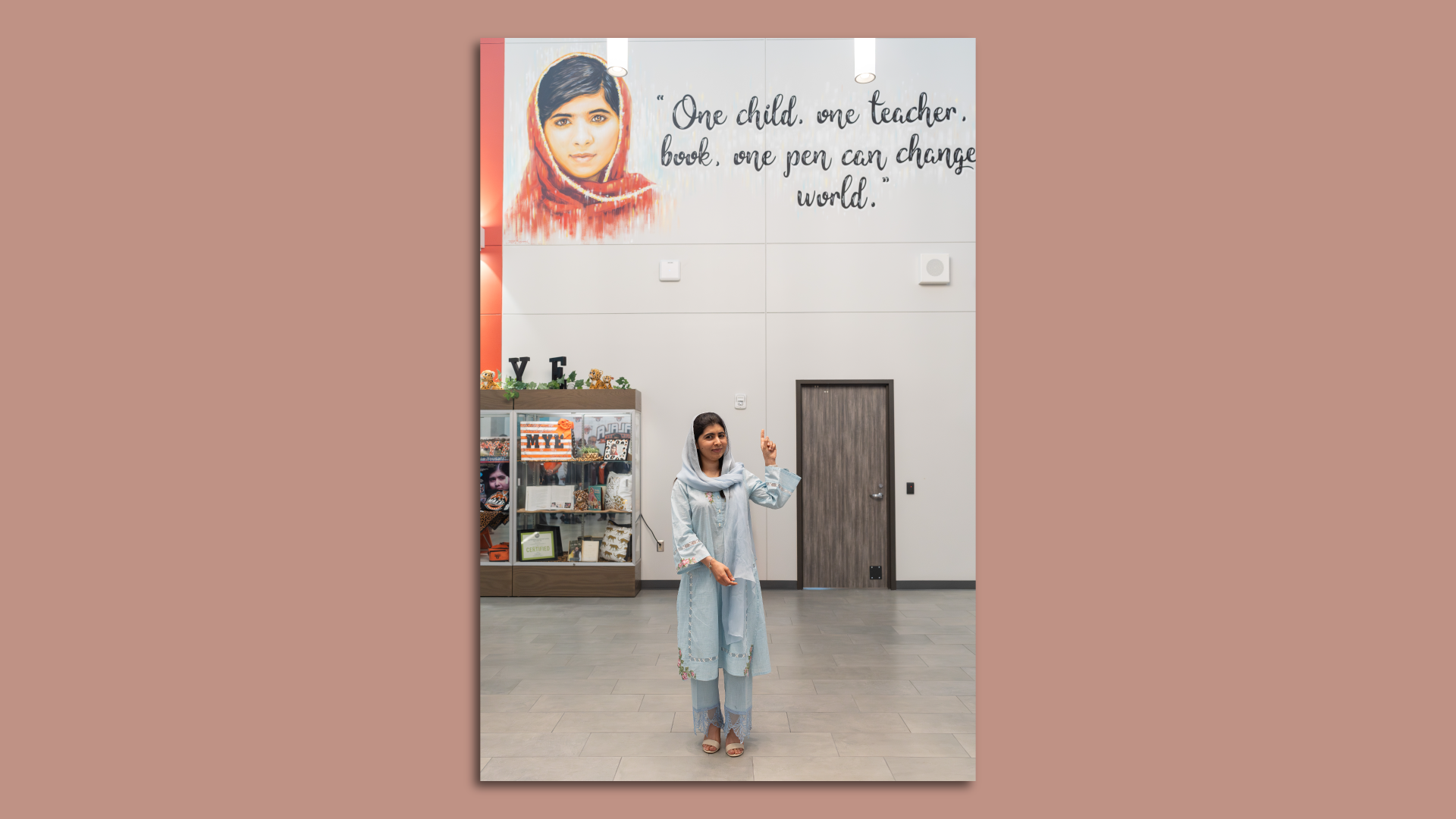 Photo of Malala in front of a mural that has her quote. 