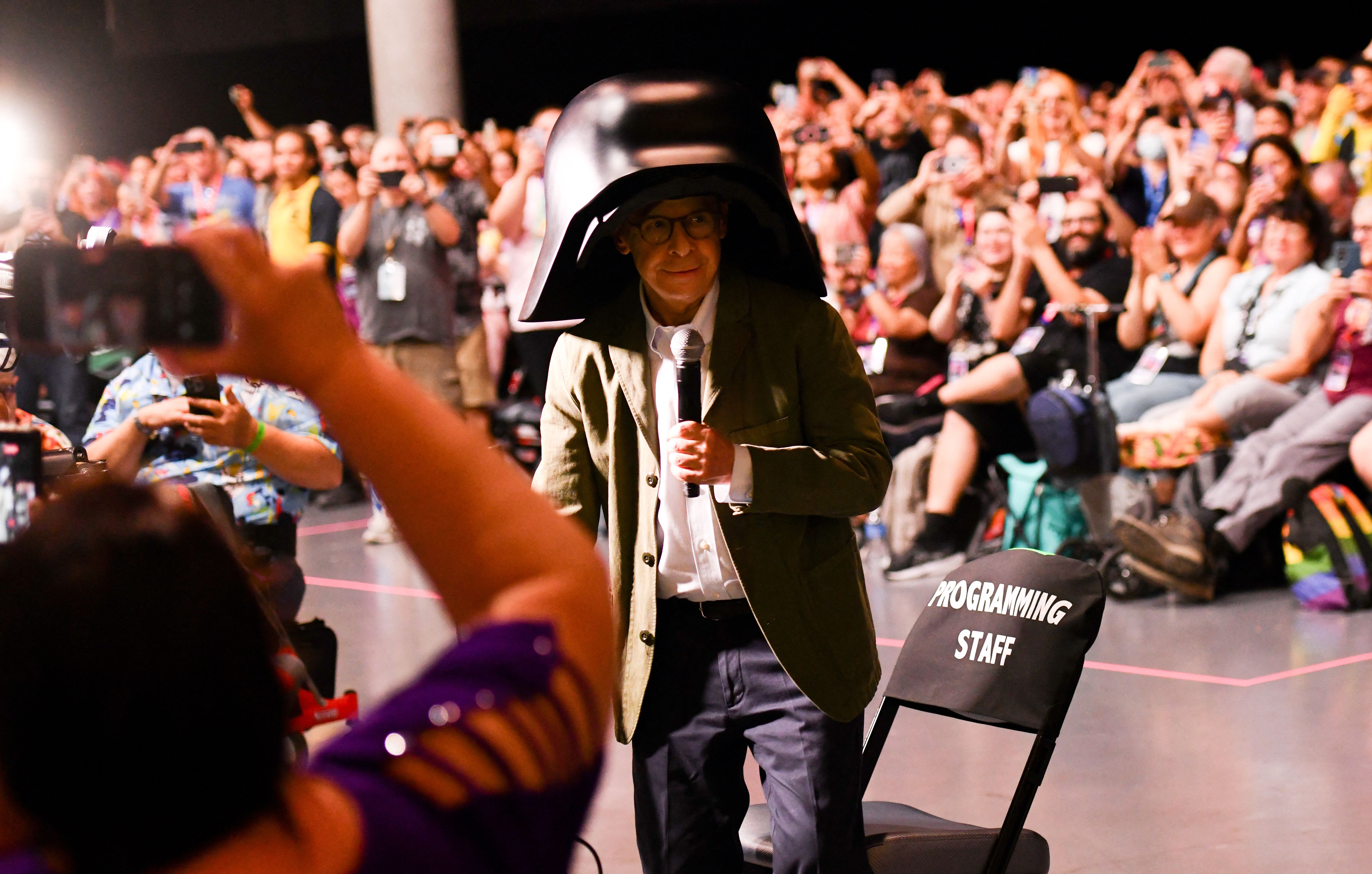 Actor Rick Moranis wears the oversized black helmet and costume of his "Spaceballs" character, Lord Dark Helmet, during a panel for "Spaceballs: The New One" at Comic-Con International in San Diego.