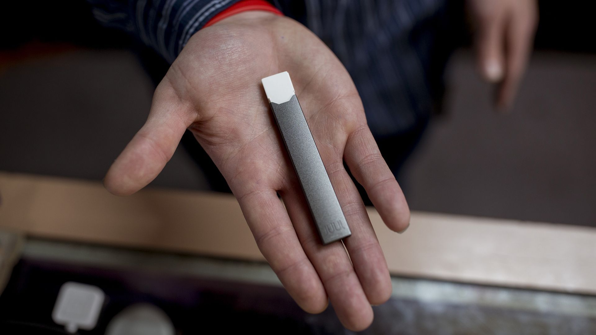 Hand holding a Juul e-cigarette