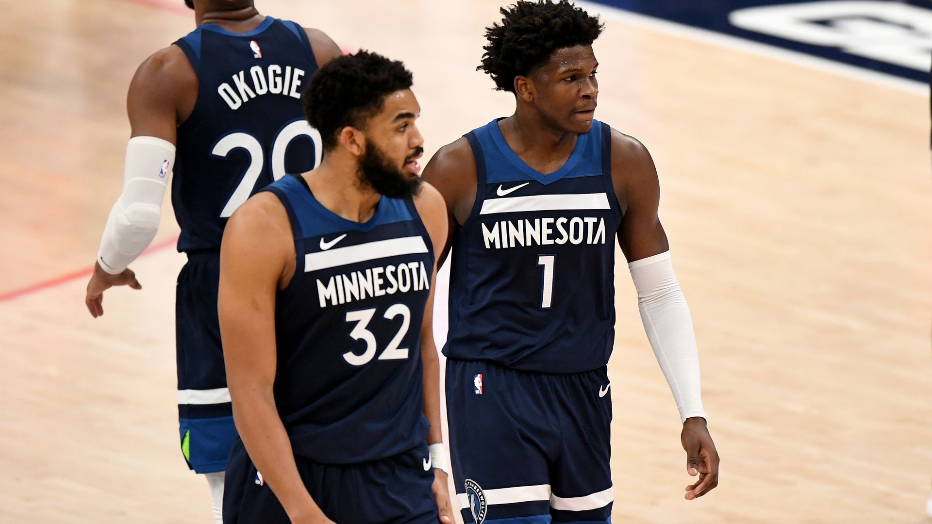 Karl-Anthony Towns and Anthony Edwards walk across the basketball court