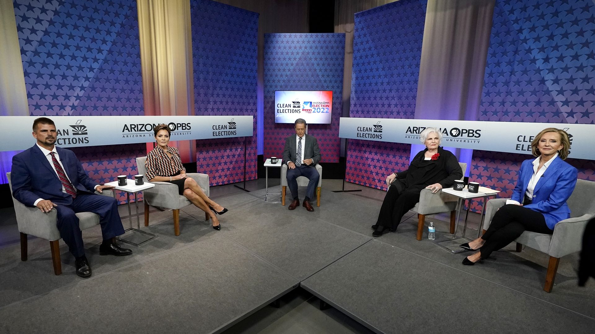 Five people sit in a television studio.