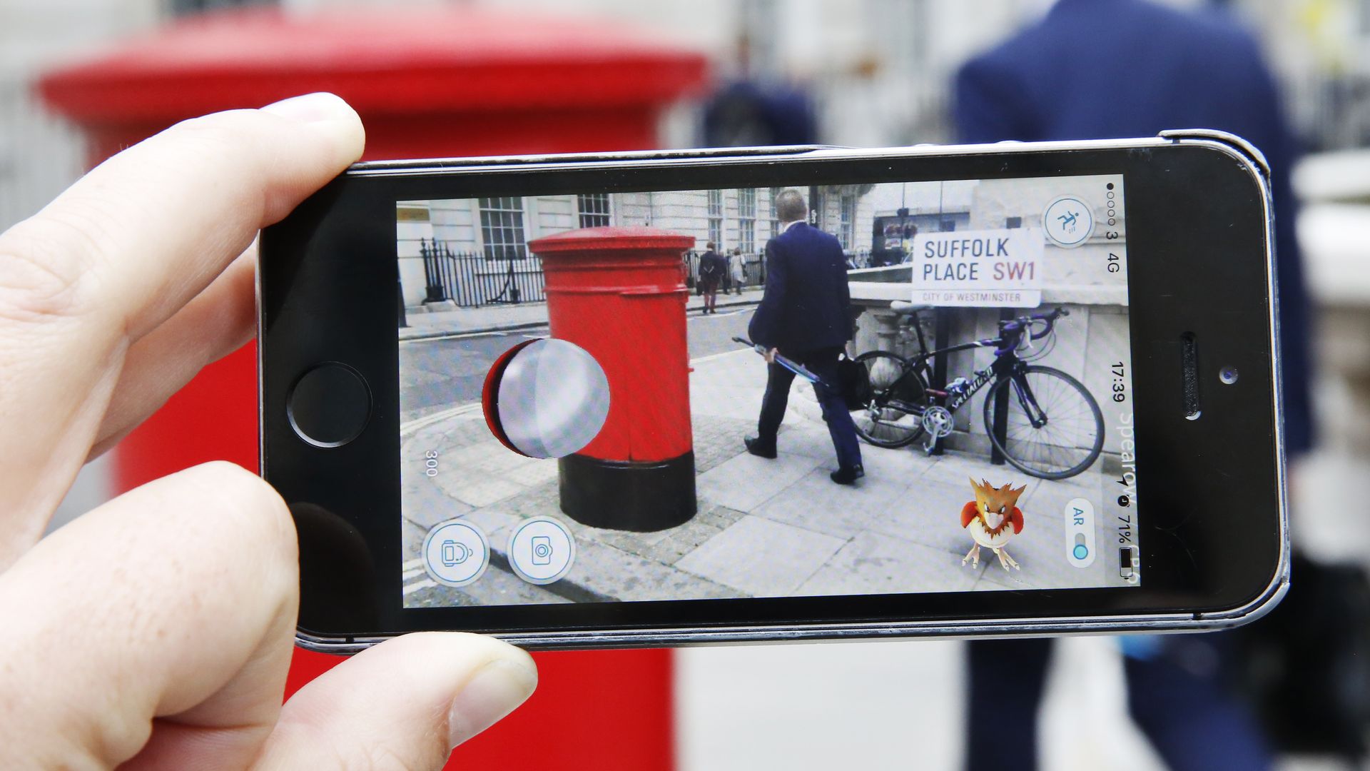 A person aims a phone camera at someone on a street