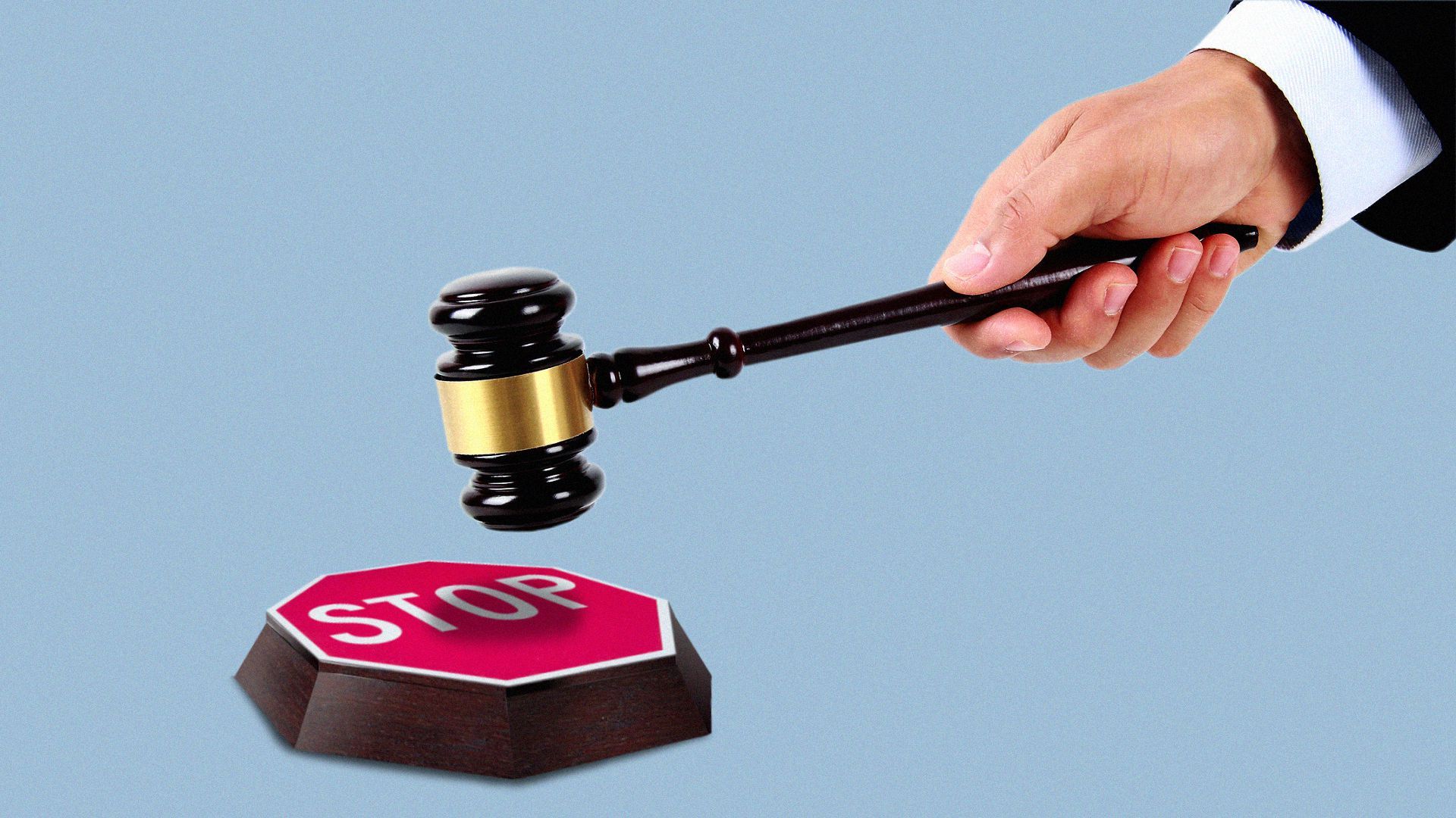 Hand holding gavel about to hit a stop sign block.