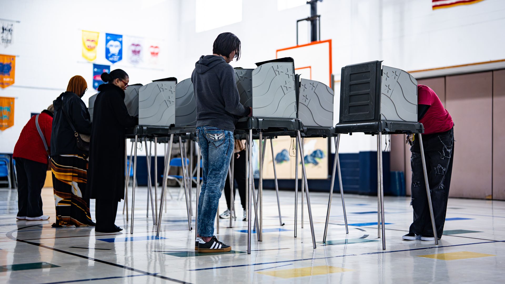 Voters stand at polling booths to cast their ballots inside an elementary school gym in Durham.