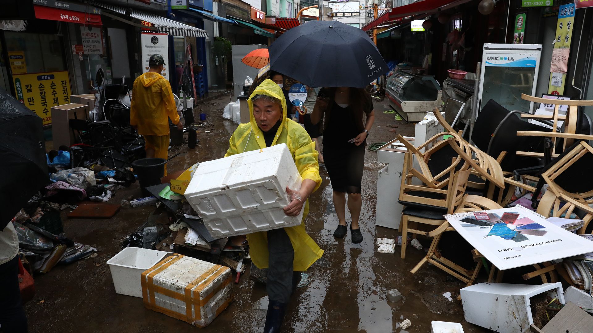 People clean up debris at a traditional market damaged by flood after torrential rain on August 09, 2022 in Seoul, South Korea