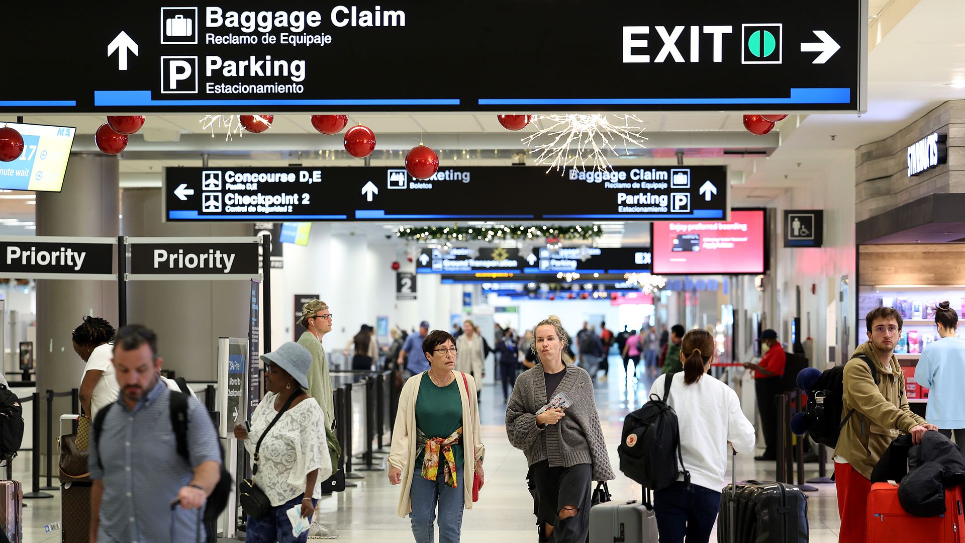 Passengers walk through Miami International Airport.