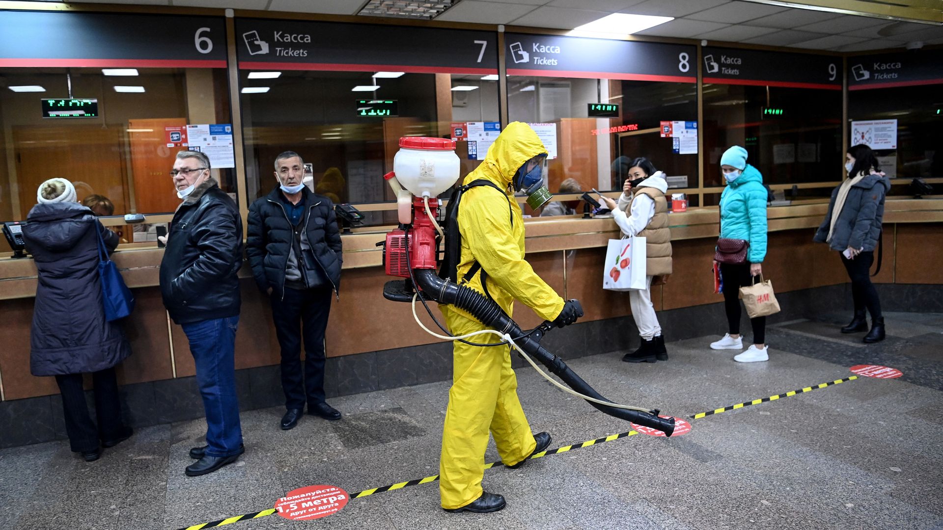 A serviceman of Russia's Emergencies Ministry wearing protective gear disinfects Moscow's Belorussky railway station on October 20, 2021