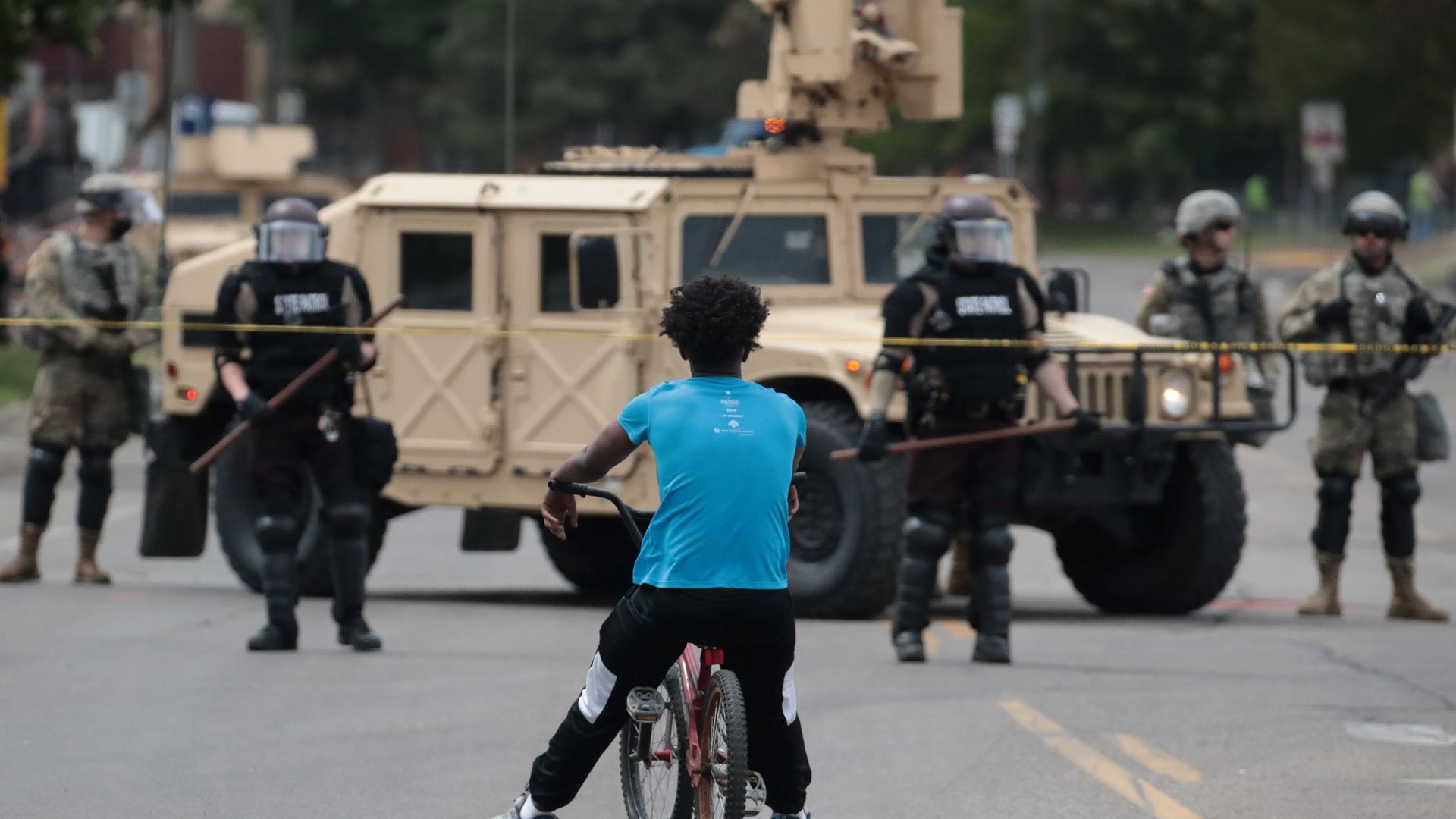 A man rides a bicycle up to a law enforcement checkpoint today in Minneapolis.