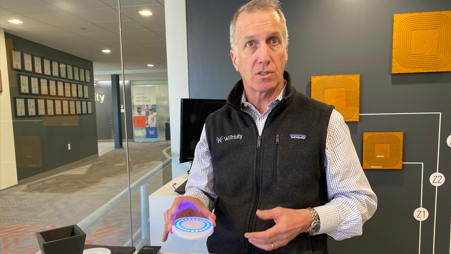 WiTricity CEO holds a light-up blue disk that helps demonstrate the company's wireless charging product.