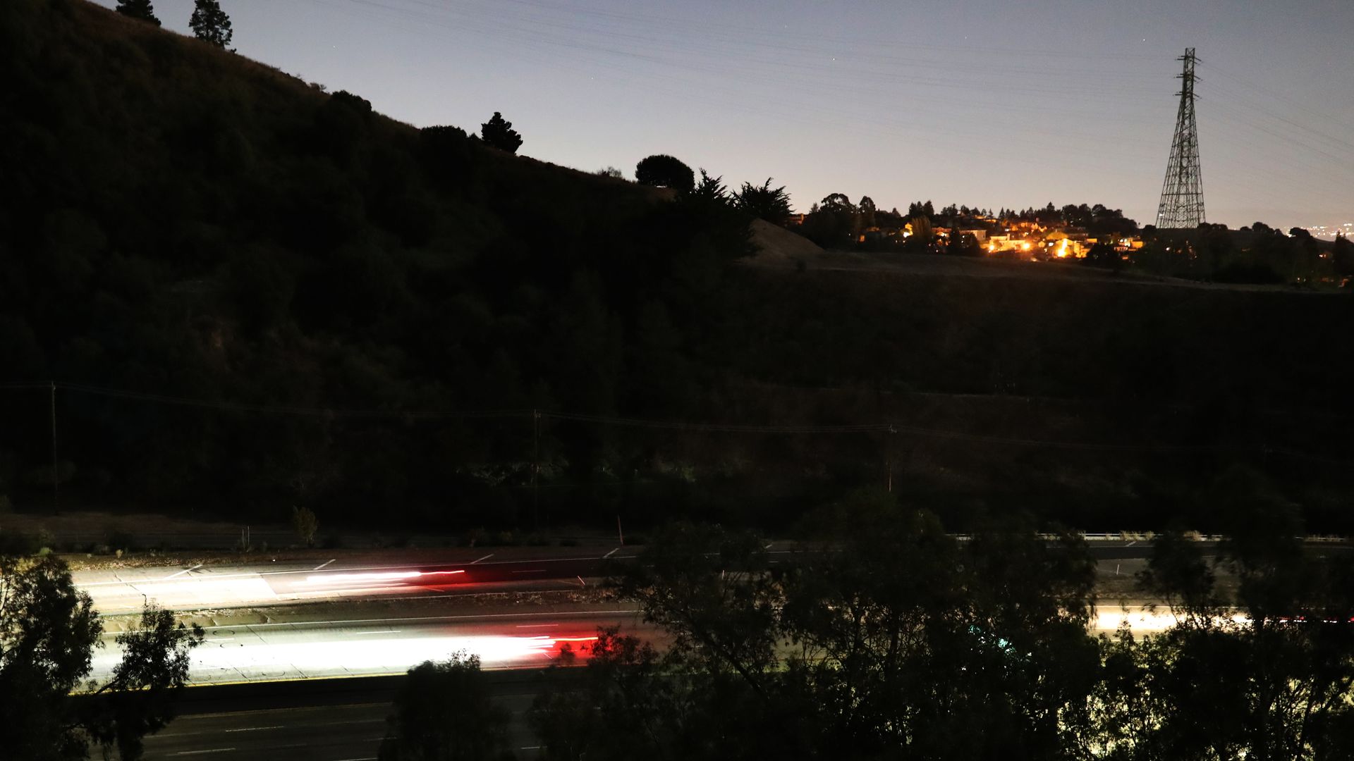Streaks of lights from vehicles drive along highway 24 during the PG&E power outage in Oakland, Calif