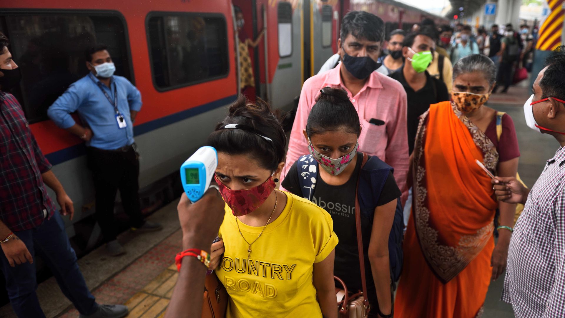 A health worker checks temperature of a passenger before conducting Covid-19 test, at Dadar station, on Aug. 26, in Mumbai, India.