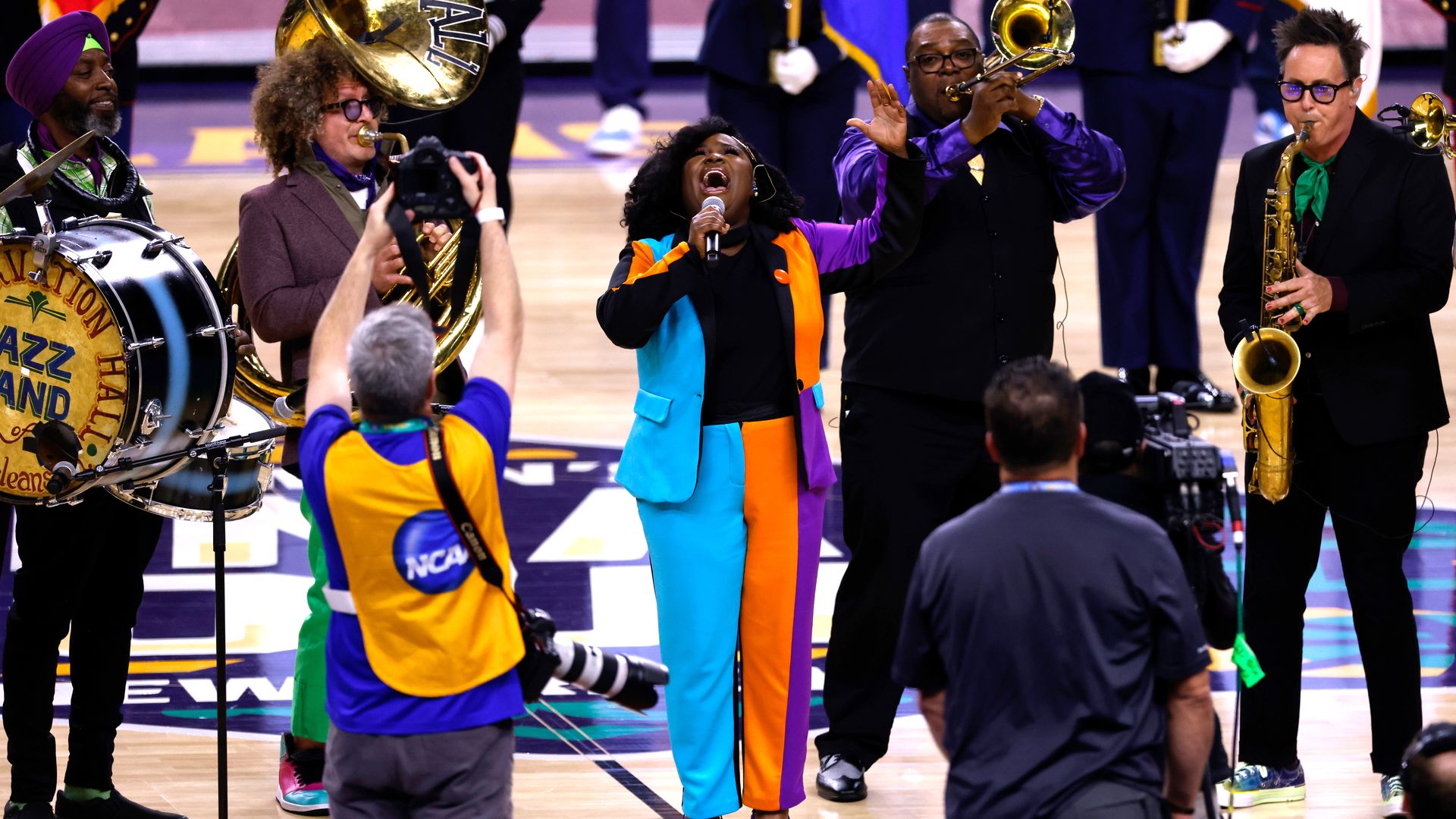 Tank Ball sings into a microphone as she's backed by the Preservation Hall Jazz Band.