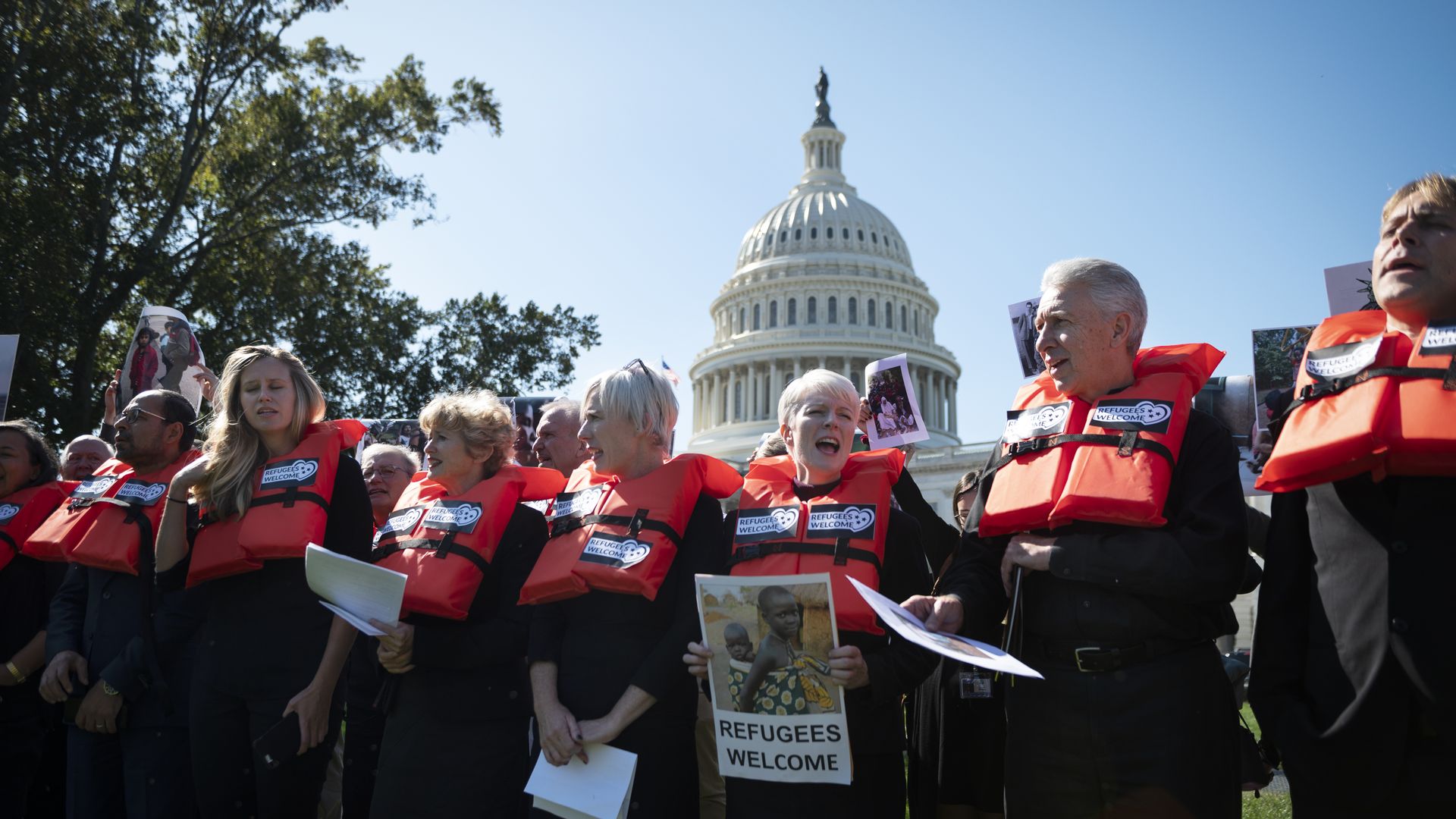Refugee protesters wear orange life jackets in Washington.