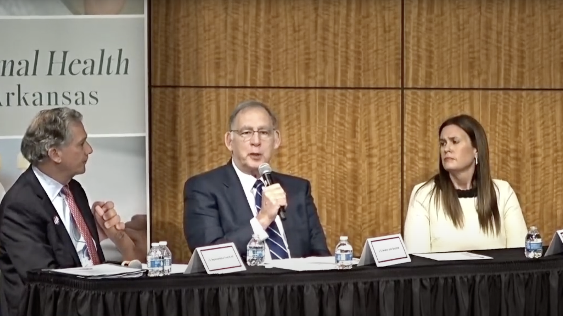 Republican Sen. John Boozman speaks while Gov. Sarah Huckabee Sanders and Rep. French Hill listen. Screenshot courtesy Sen. John Boozman's YouTube channel.