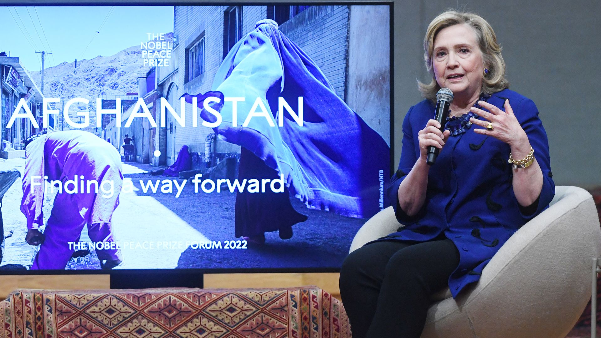Photo of Hillary Clinton speaking while sitting on stage