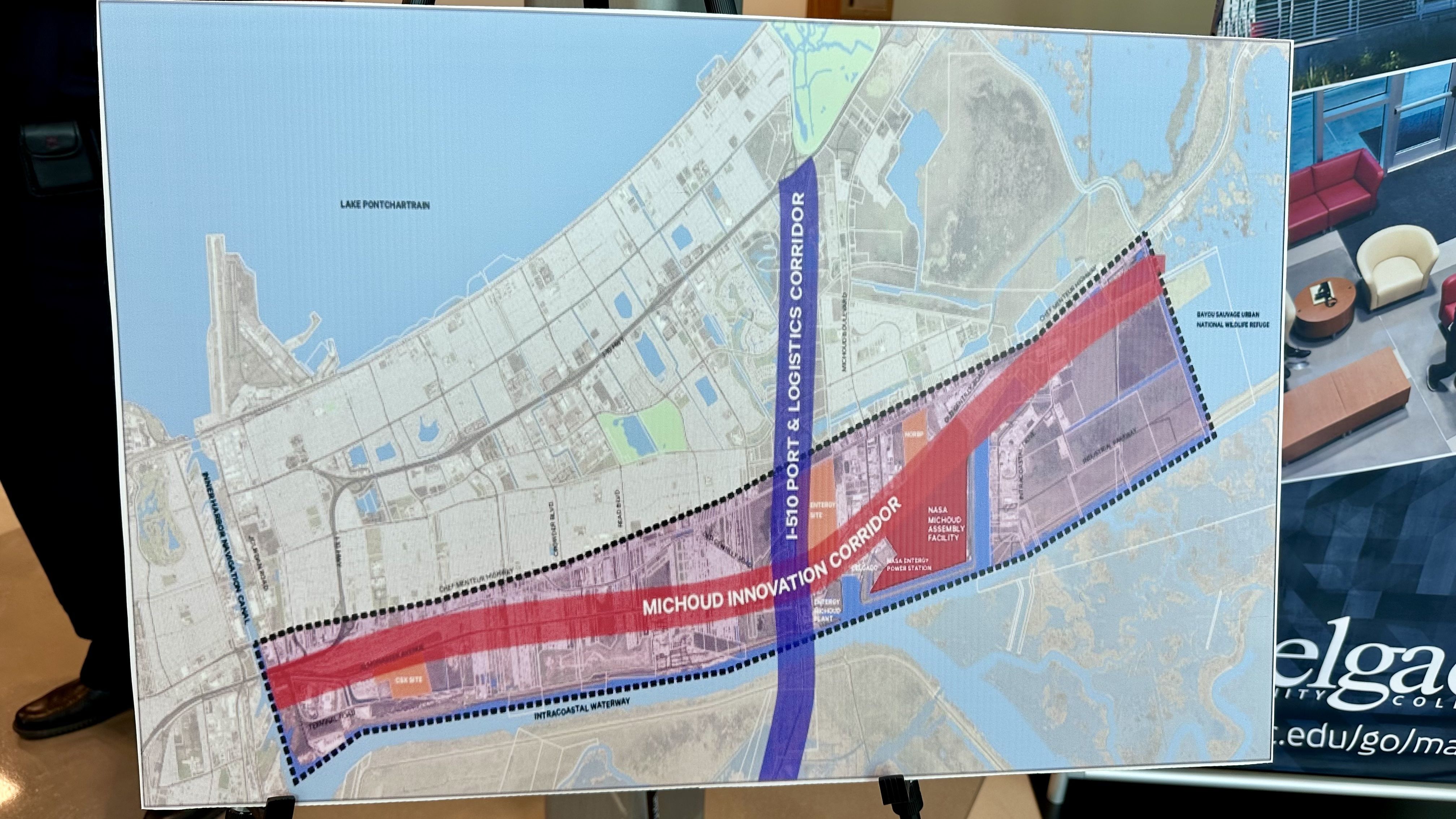 Map on a board of a coastal city with blue water on the left; bold purple and red diagonal corridors labeled "Port & Logistics Corridor" and "Michoud Innovation Corridor" run across streets.