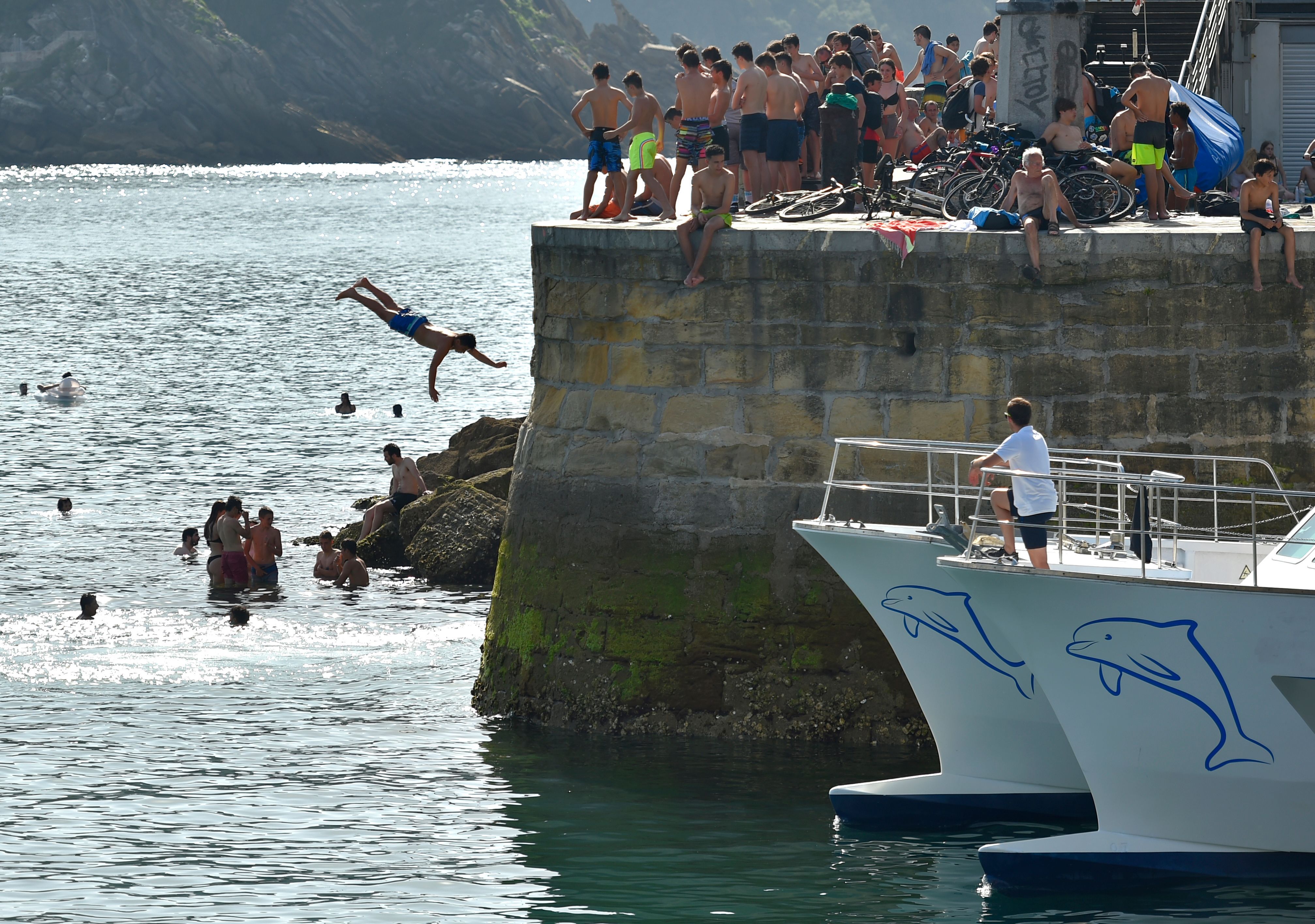 A man dives as people cool off at La Concha beach in the northern Spanish city of San Sebastian.