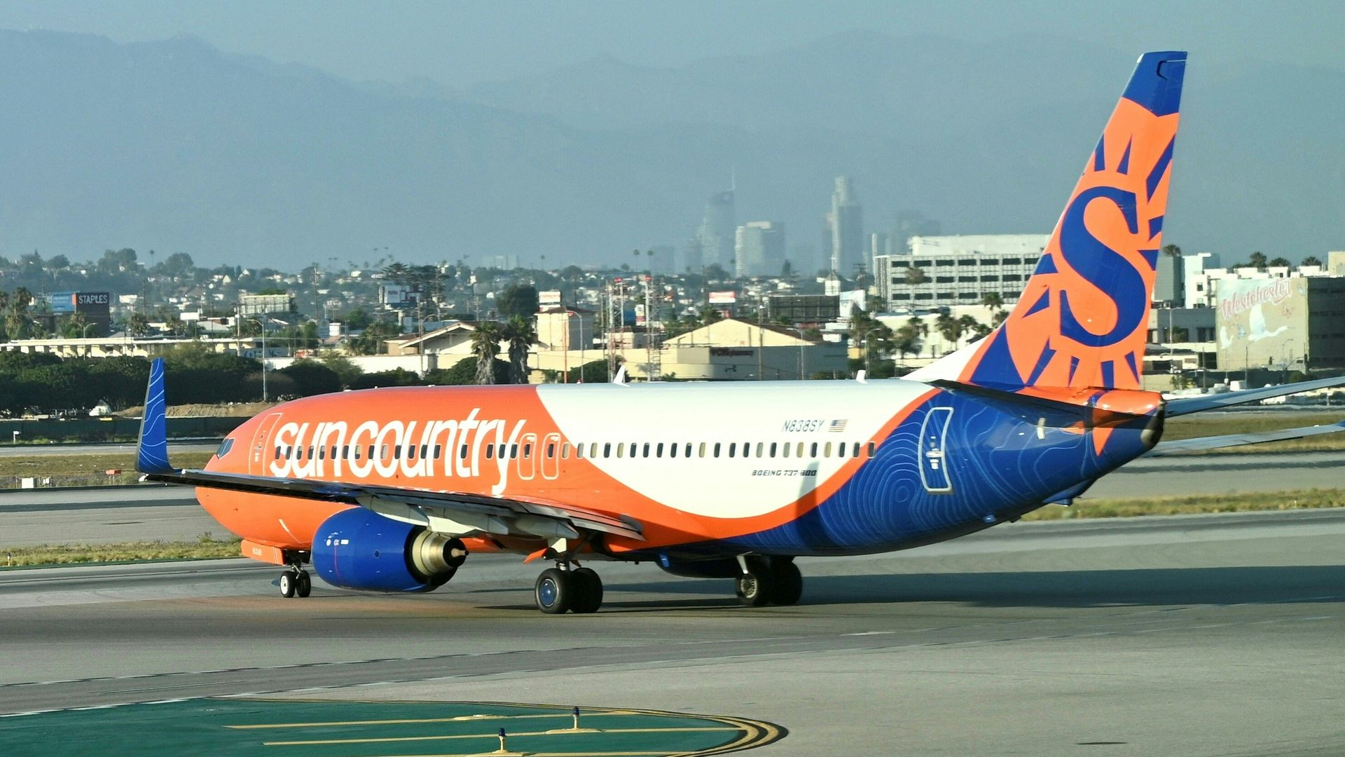 A Sun Country-branded airplane on an airport tarmac. 